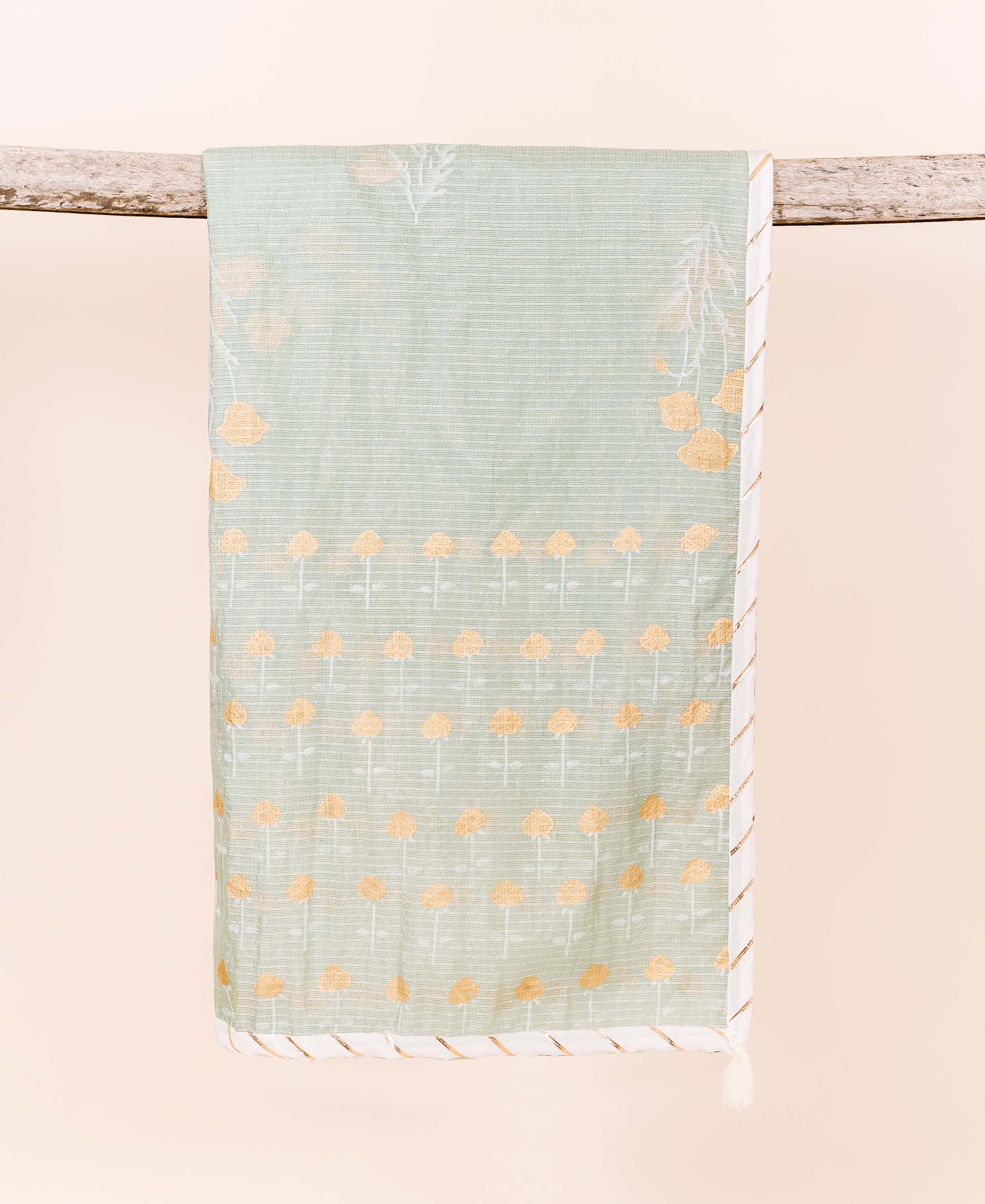 Muted green dupatta draped on wood, featuring yellow floral and white leafy block prints.
