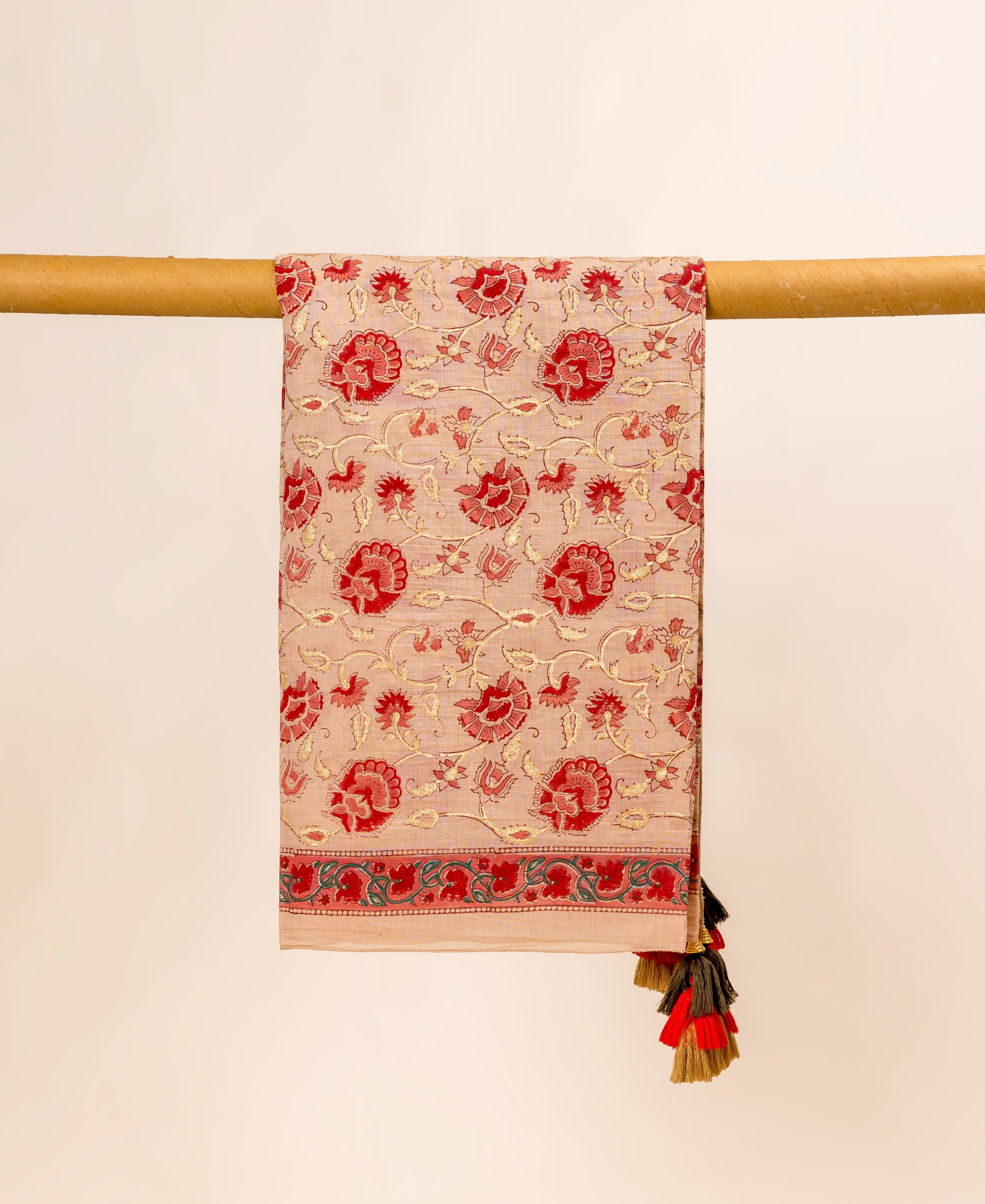 Draped beige hand block printed dupatta, red and gold floral pattern, green border, mixed tassels.