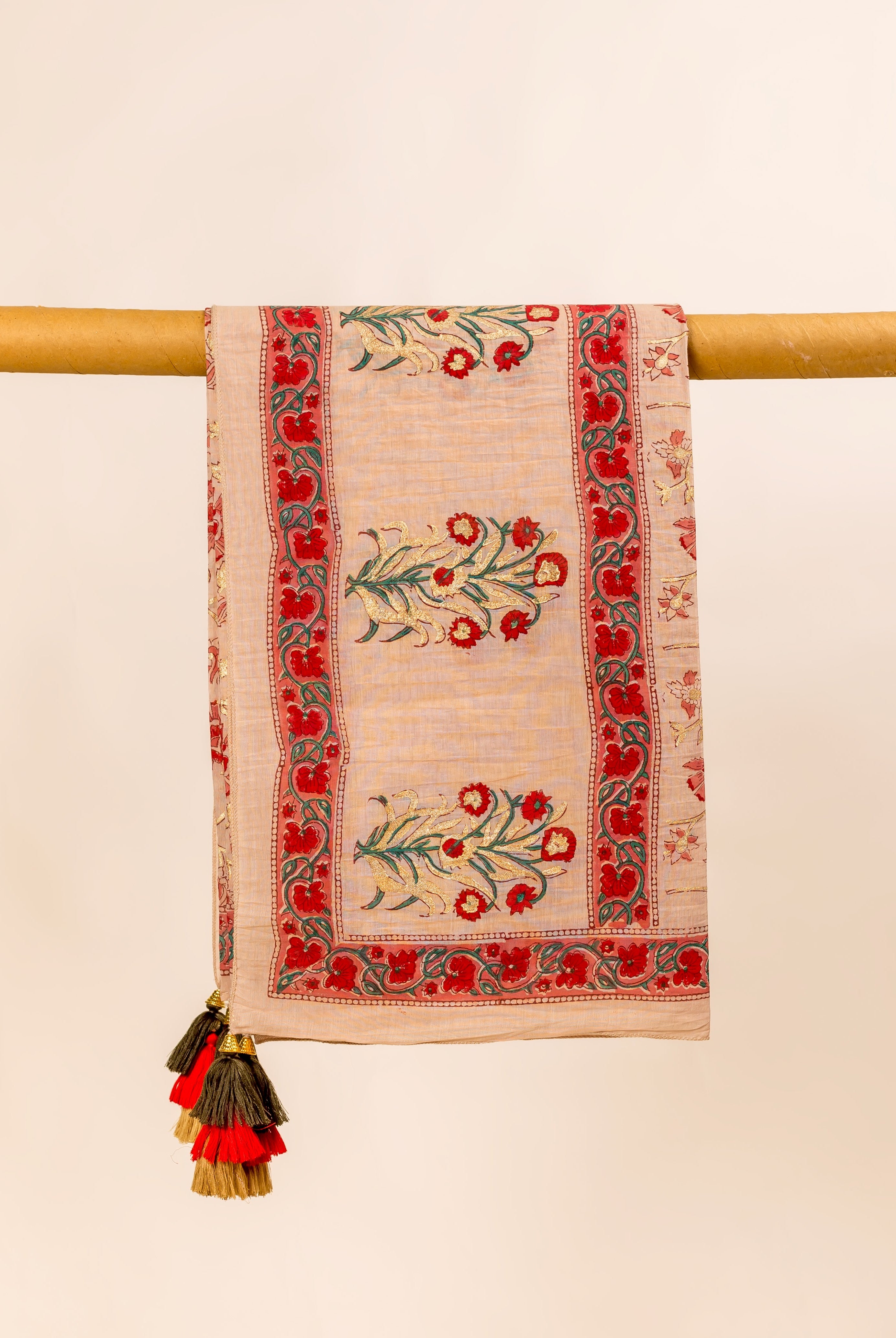 Front view of a beige hand-block-printed dupatta with red and gold floral print and tassels.