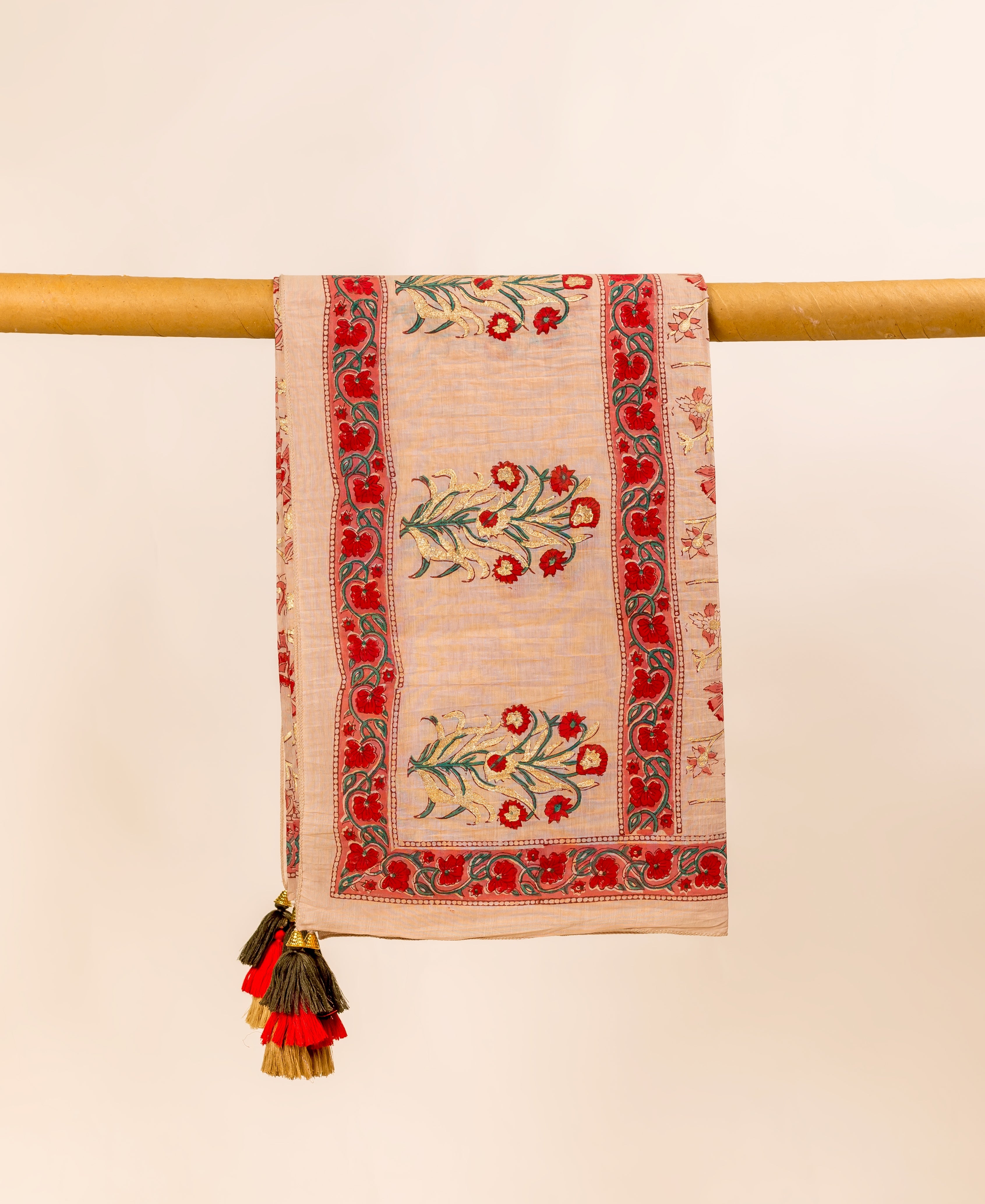 Front view of a beige hand-block-printed dupatta with red and gold floral print and tassels.