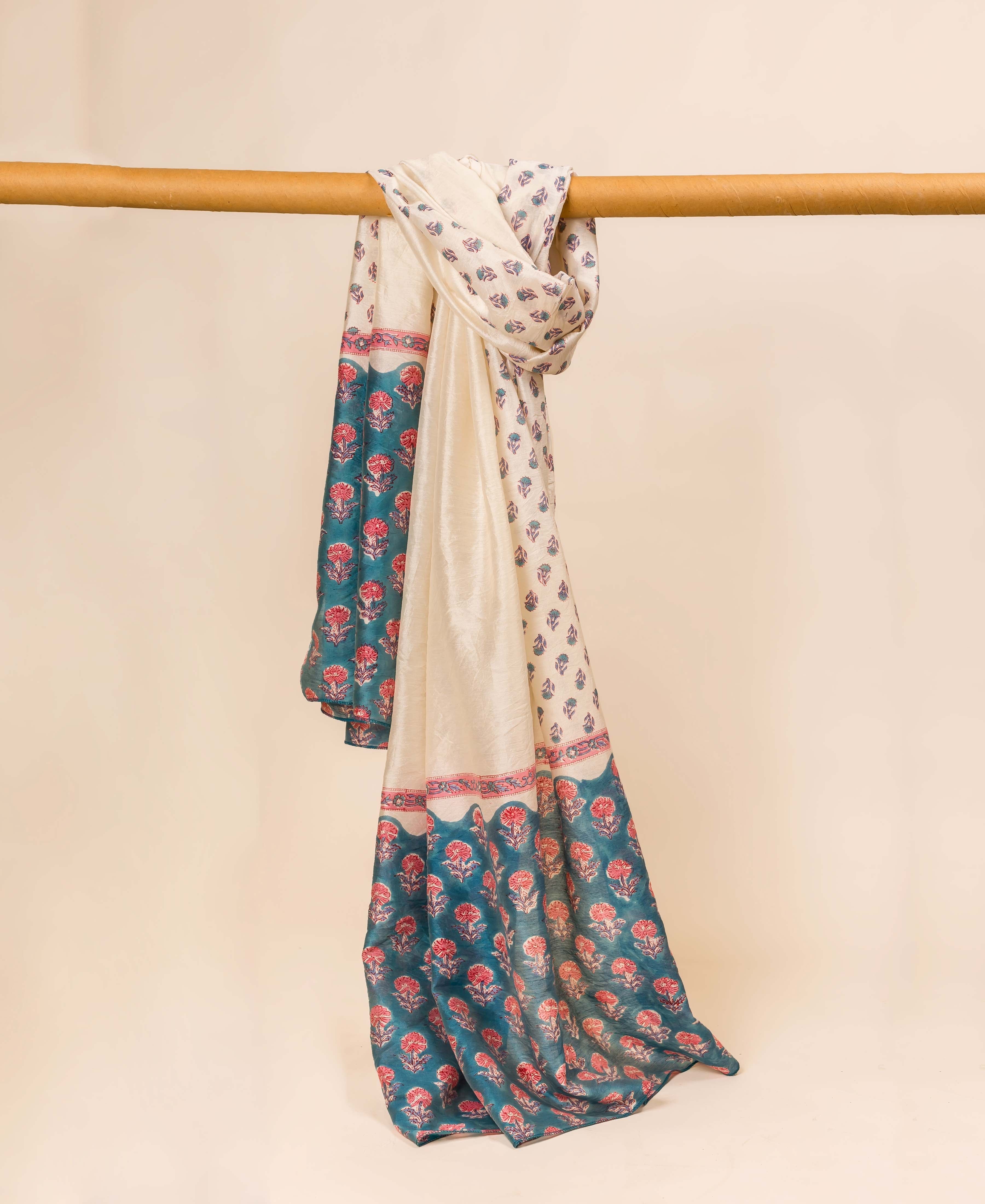 Teal blue hand block printed chanderi dupatta draped over a wooden rod.