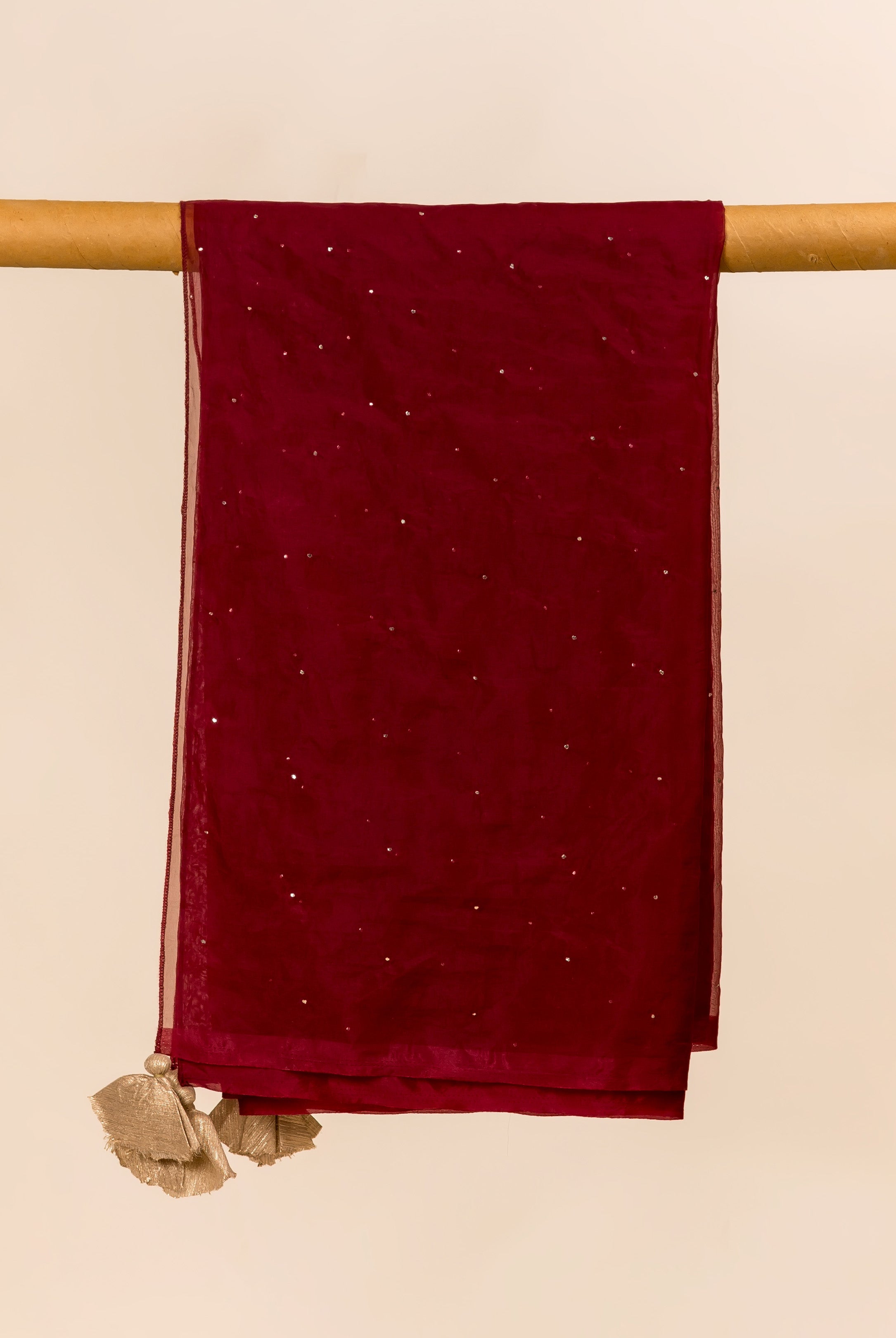 Maroon organza dupatta, featuring scattered mukaish embellishments and golden tassels, draped.