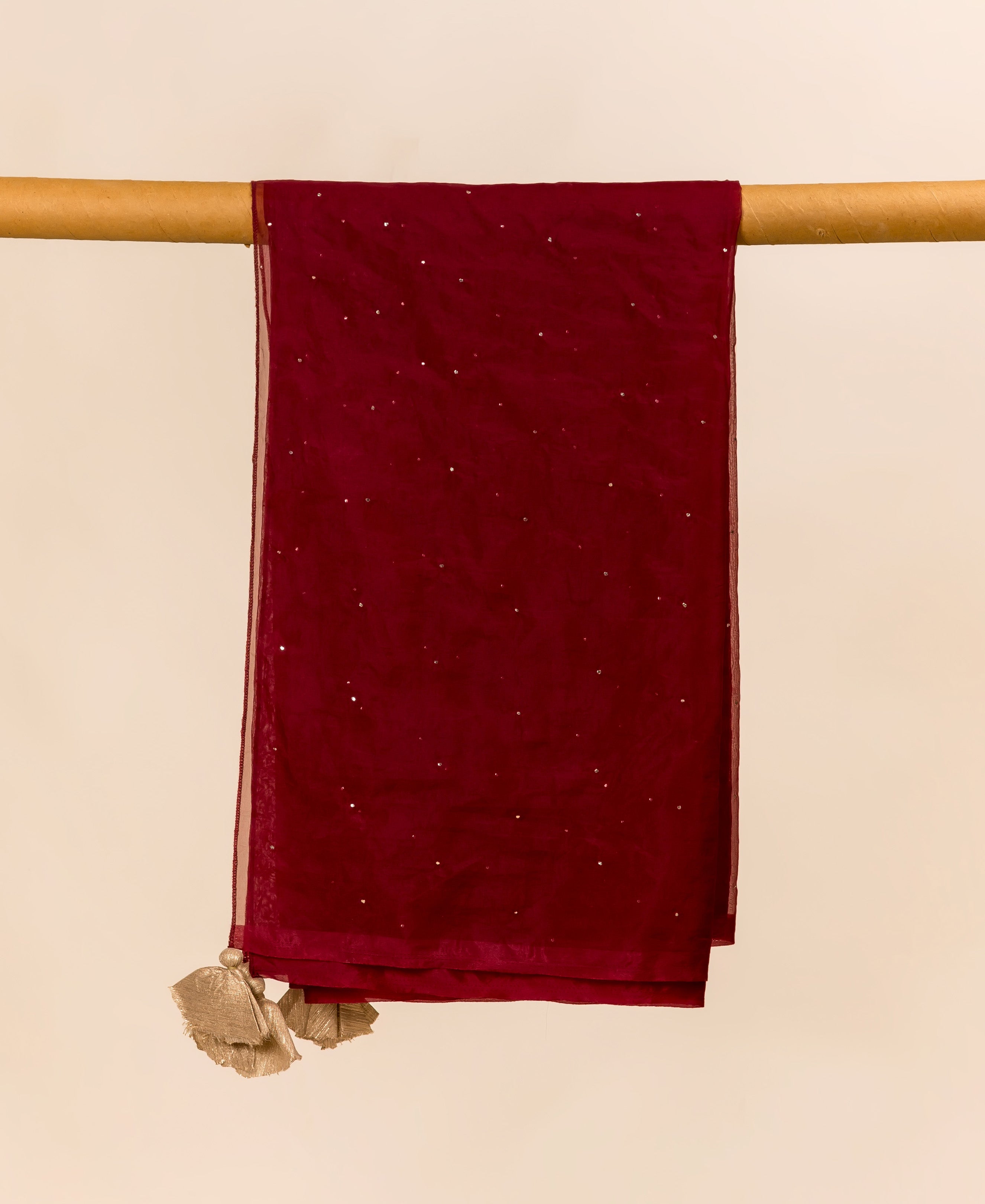 Maroon organza dupatta, featuring scattered mukaish embellishments and golden tassels, draped.