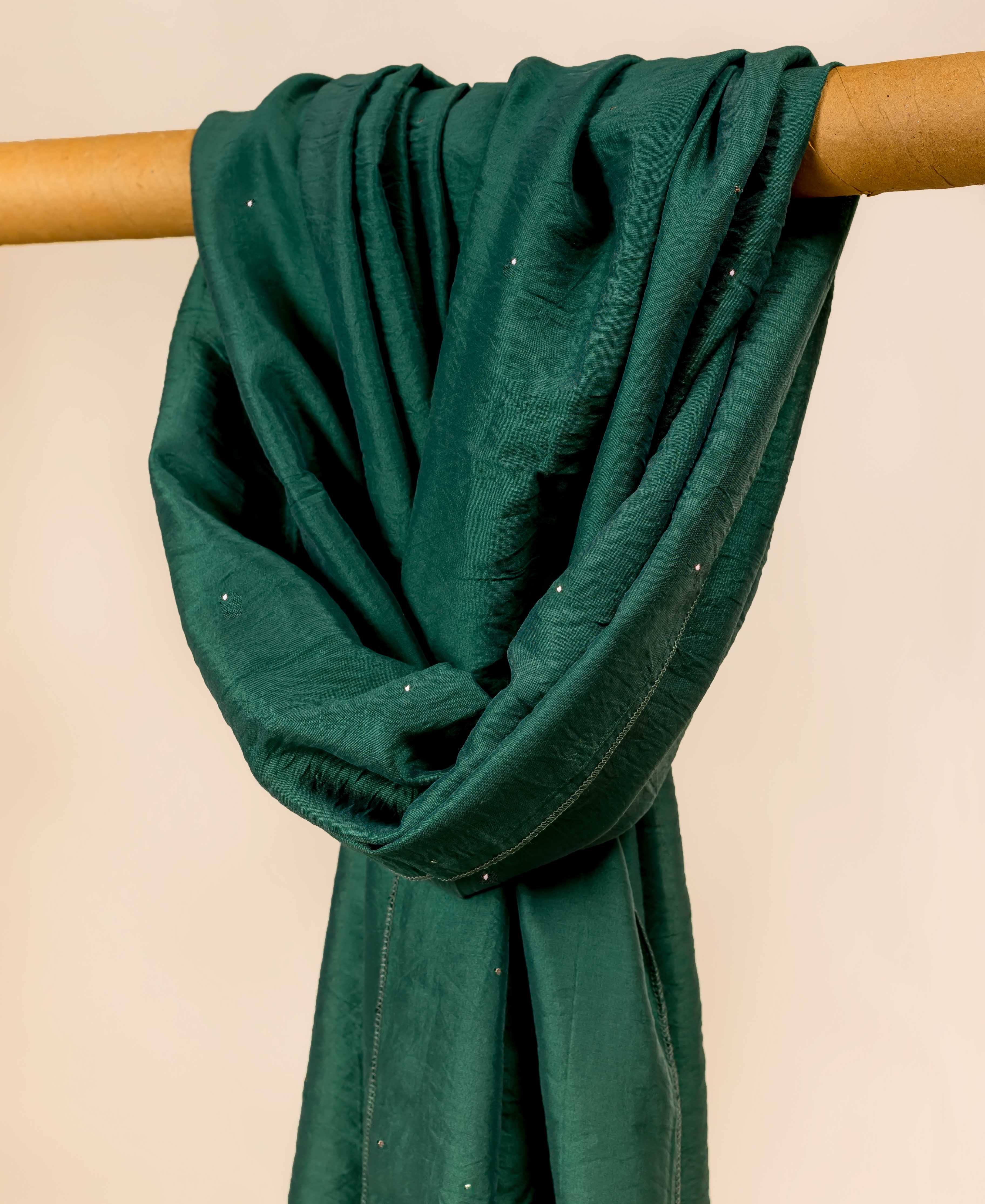 Teal green dupatta with mukaish work, draped over a cylindrical object.