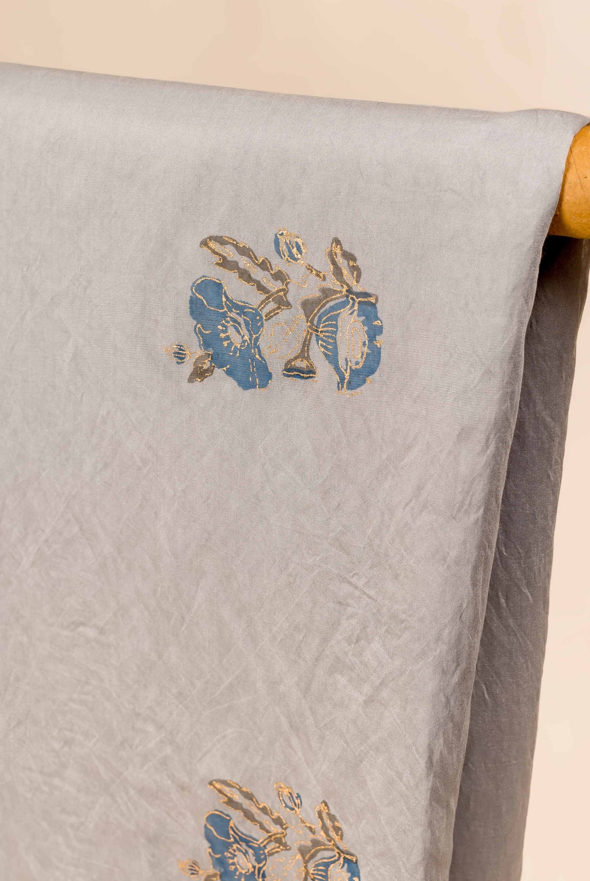 Light grey Chanderi dupatta displaying blue and gold hand block floral print.