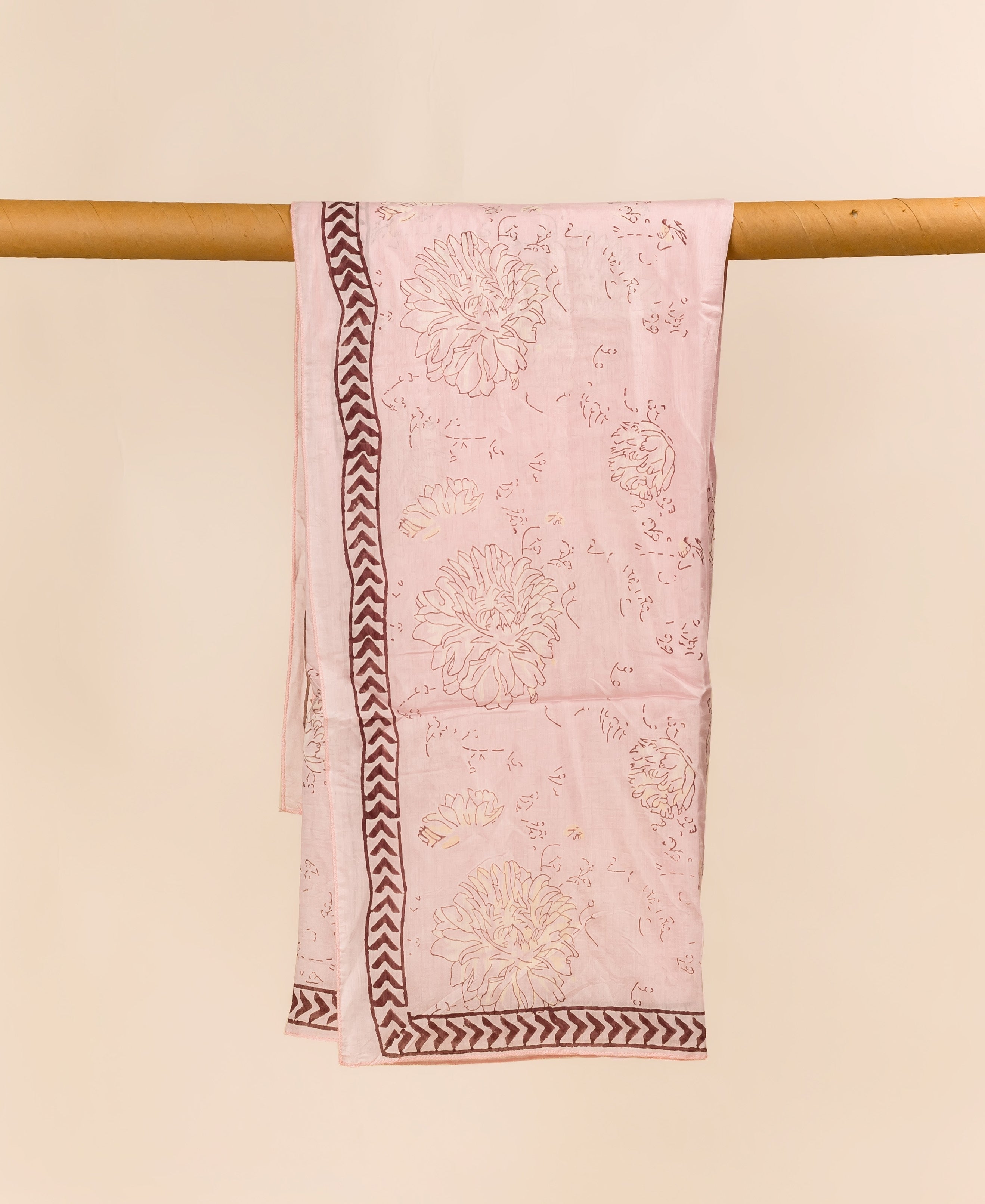 Full blush pink hand-block printed dupatta featuring floral motifs and a brown chevron border.