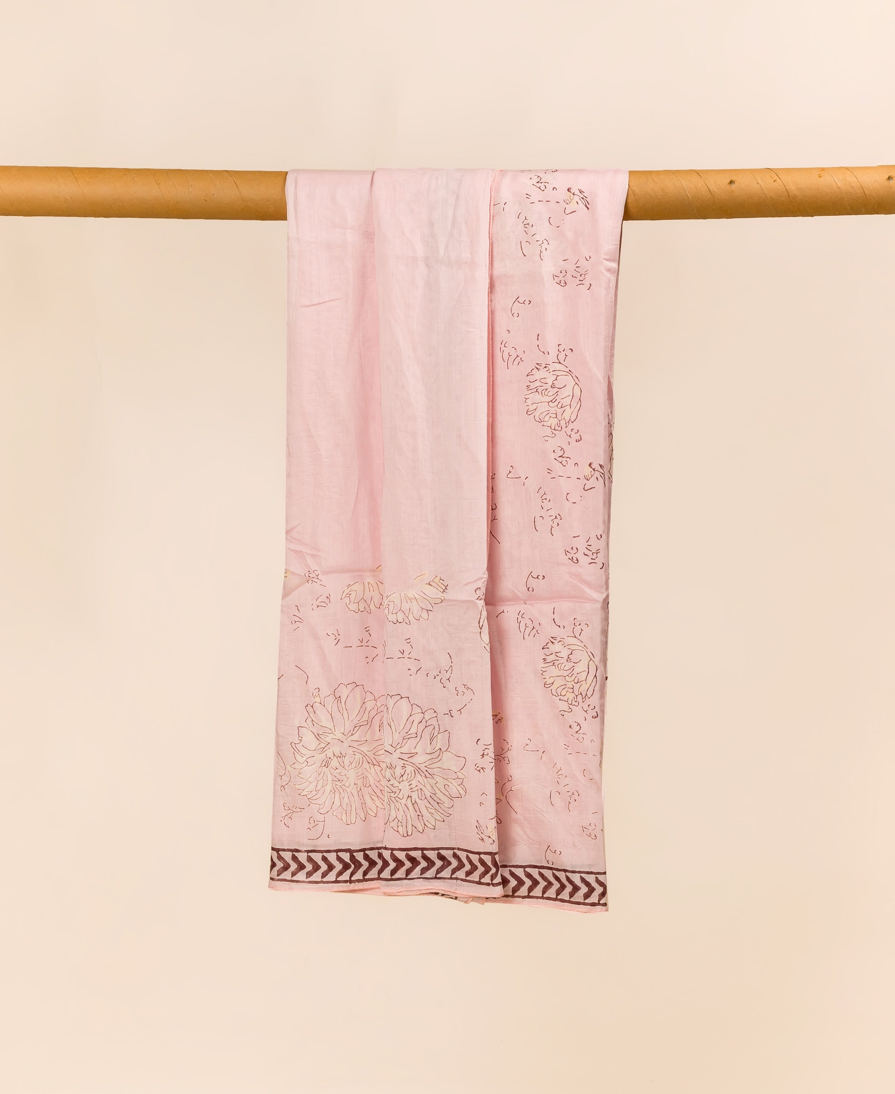 Blush pink hand block printed dupatta draped, showing floral motifs and chevron border.