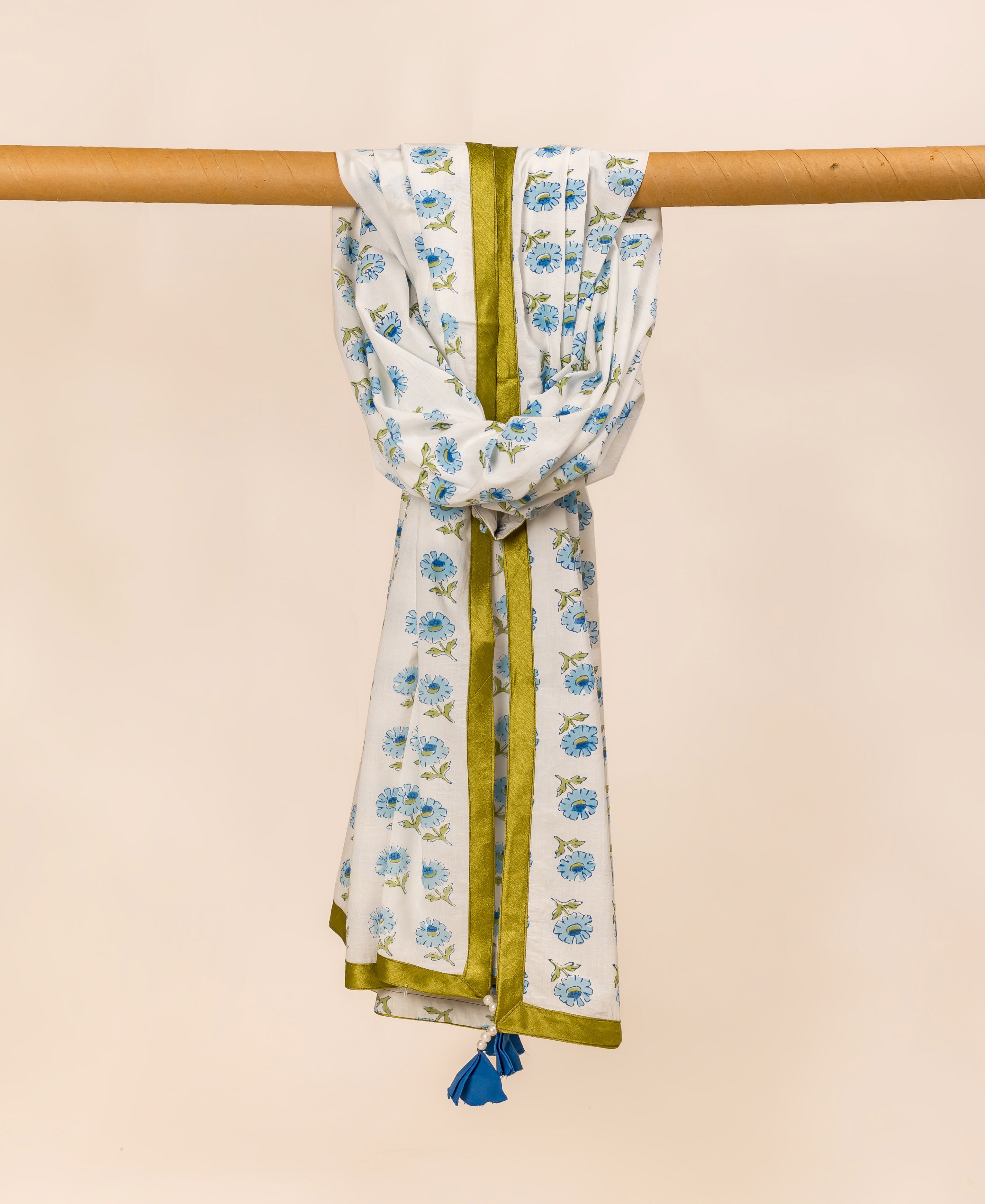 White and blue hand block printed dupatta with floral pattern, draped over a wooden rod.