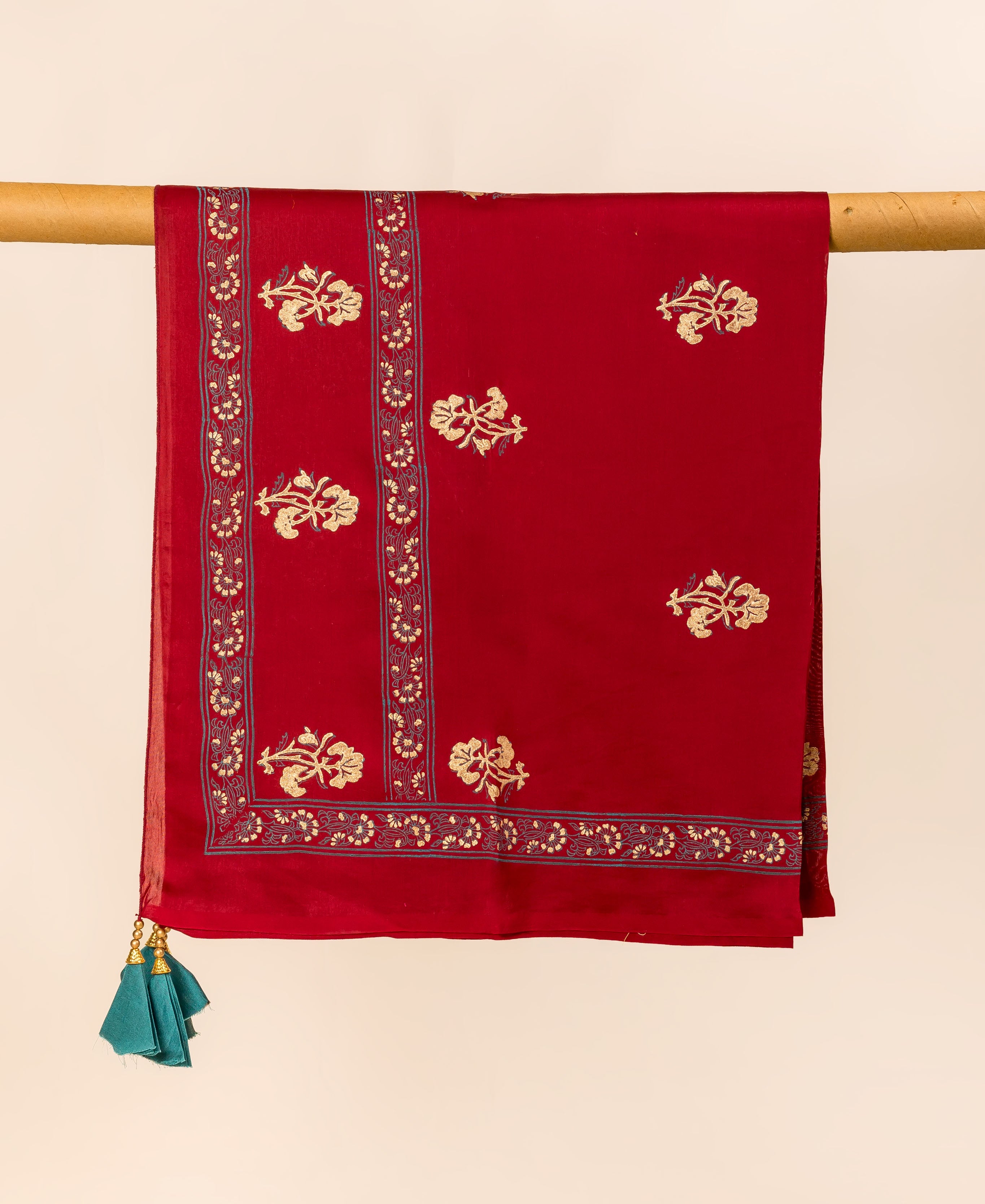 Maroon dupatta draped, featuring gold hand-block printed floral patterns, ornate borders, and teal tassels.