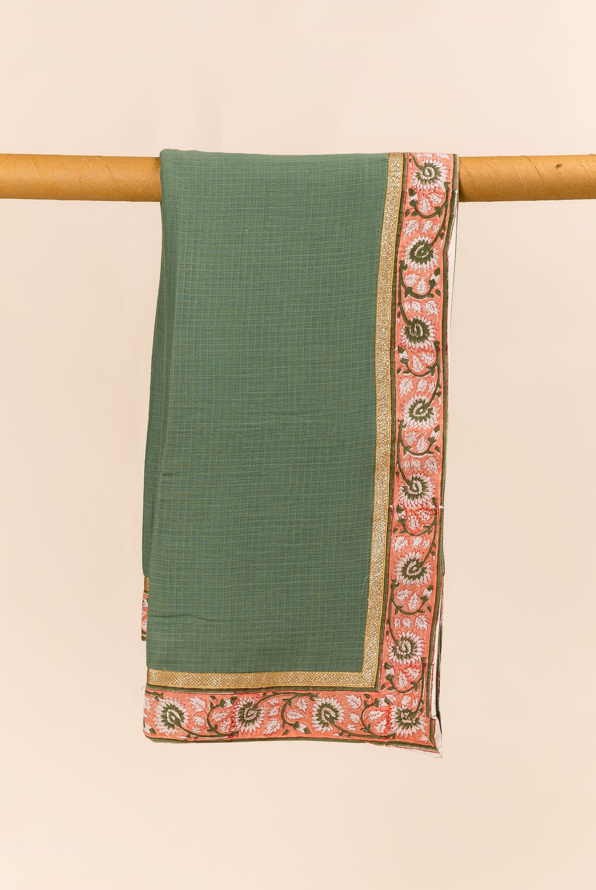 Green textured dupatta with peach floral block print border and golden trim, draped.