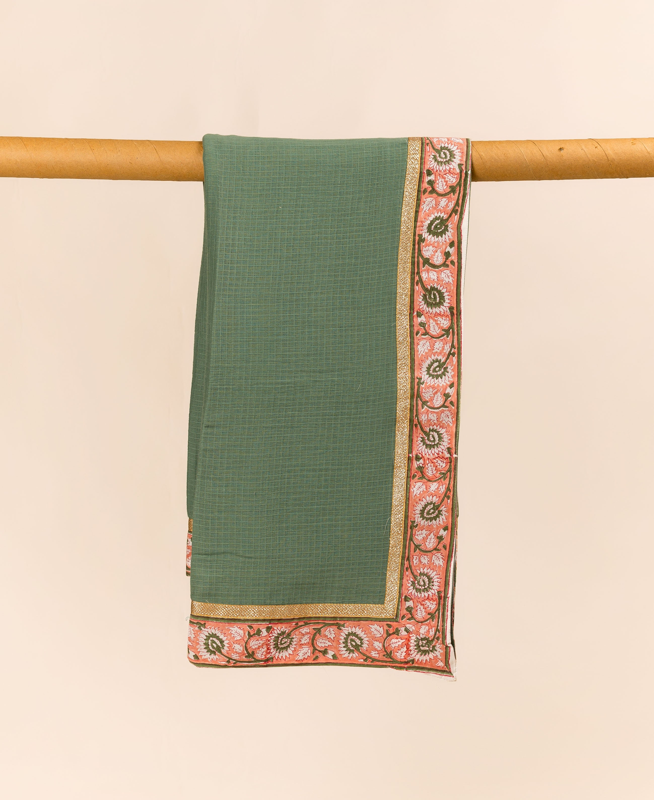 Green textured dupatta with peach floral block print border and golden trim, draped.