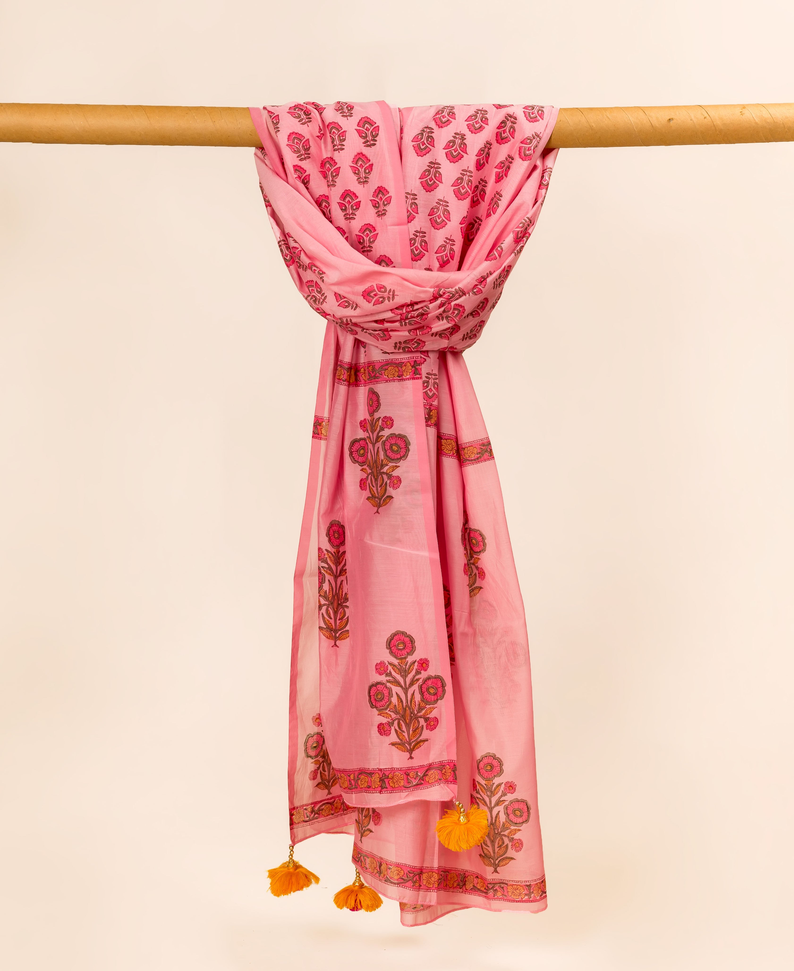 Pink hand block printed dupatta featuring bold floral designs and decorative borders with orange tassels.