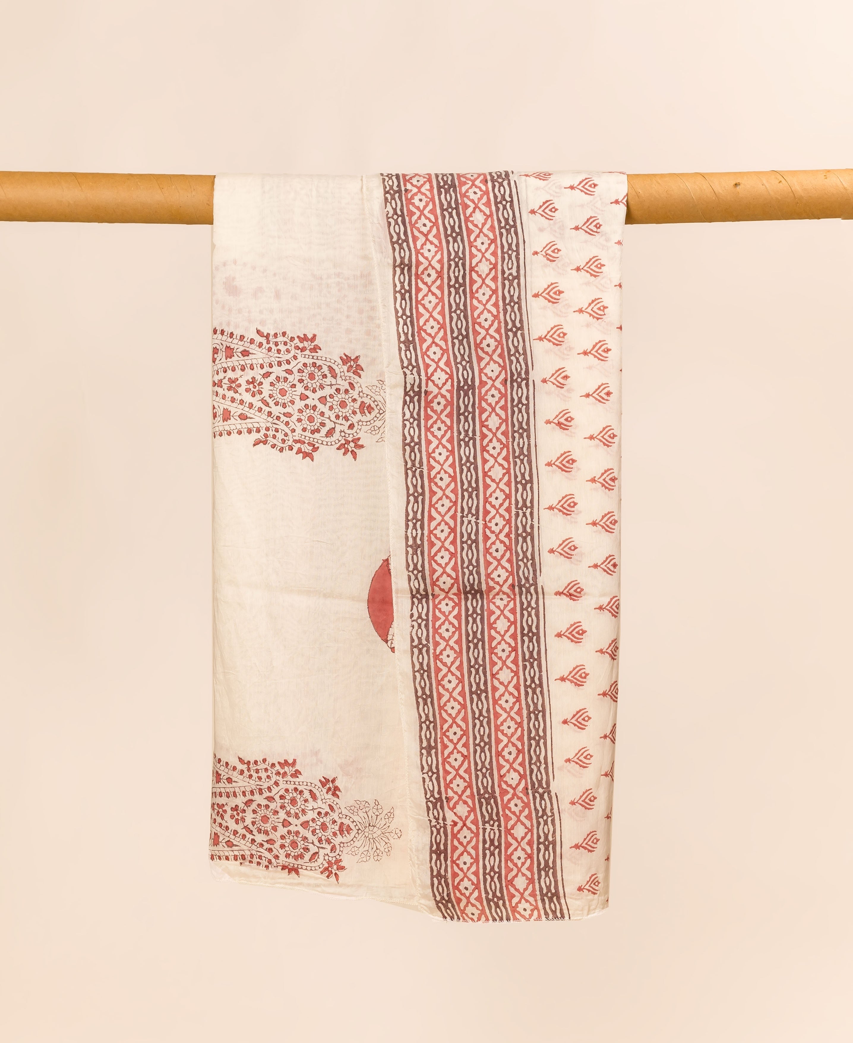 Off-white hand block printed dupatta, draped, with red floral and brown-red geometric patterns.