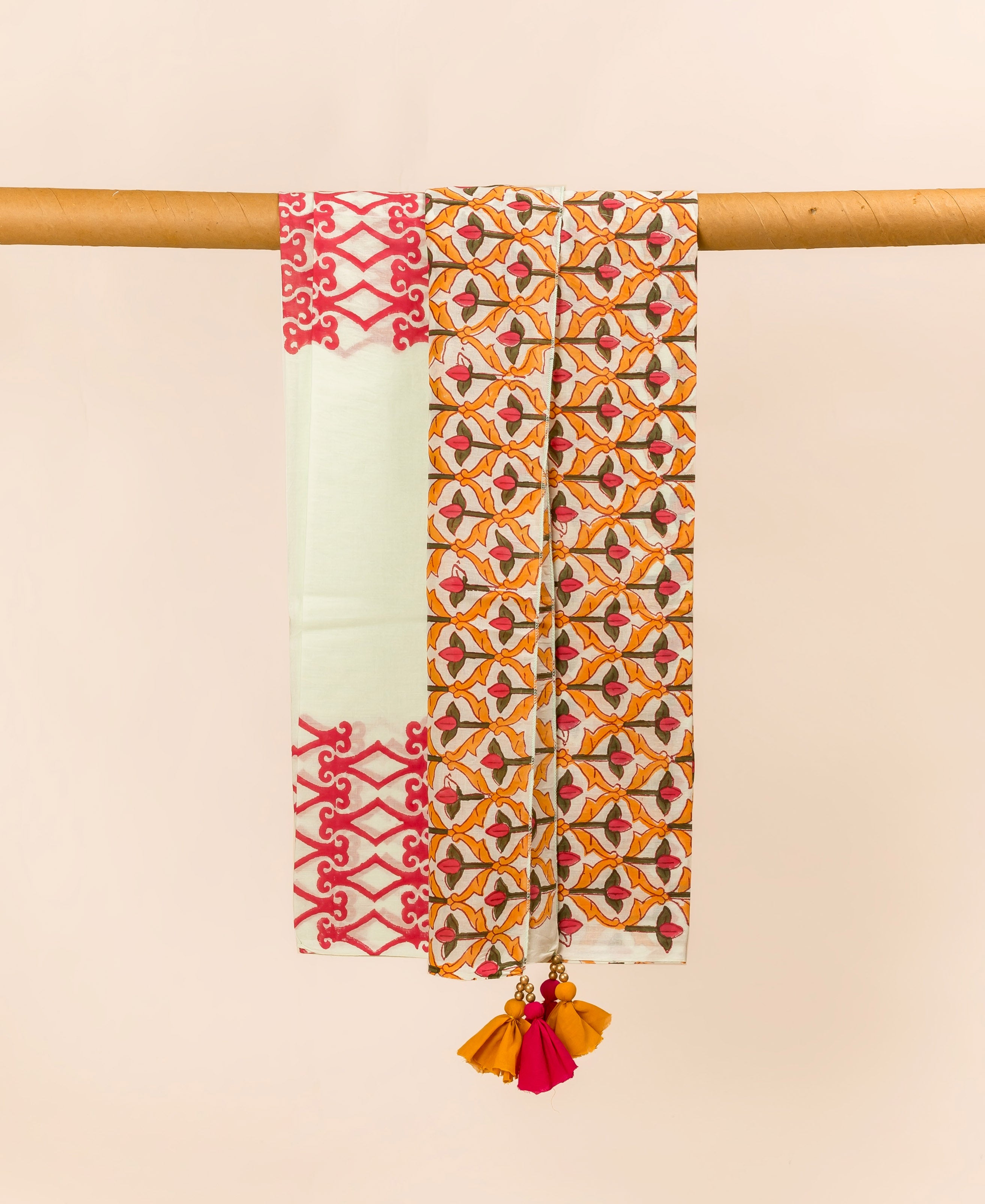 Draped lime cotton dupatta features red block print border, orange pattern, and multi-colored tassels.