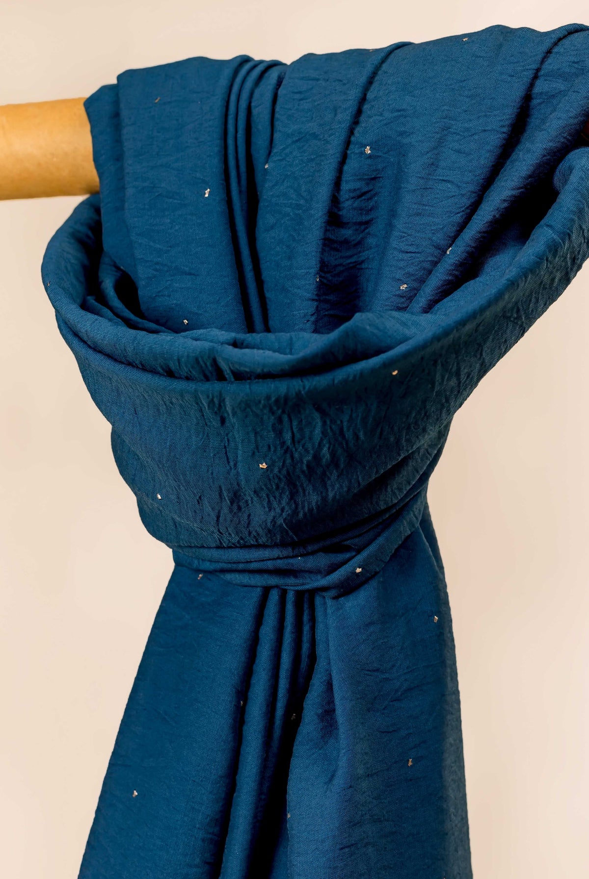 Blue Chanderi dupatta draped over a rod, featuring scattered golden mukaish work.