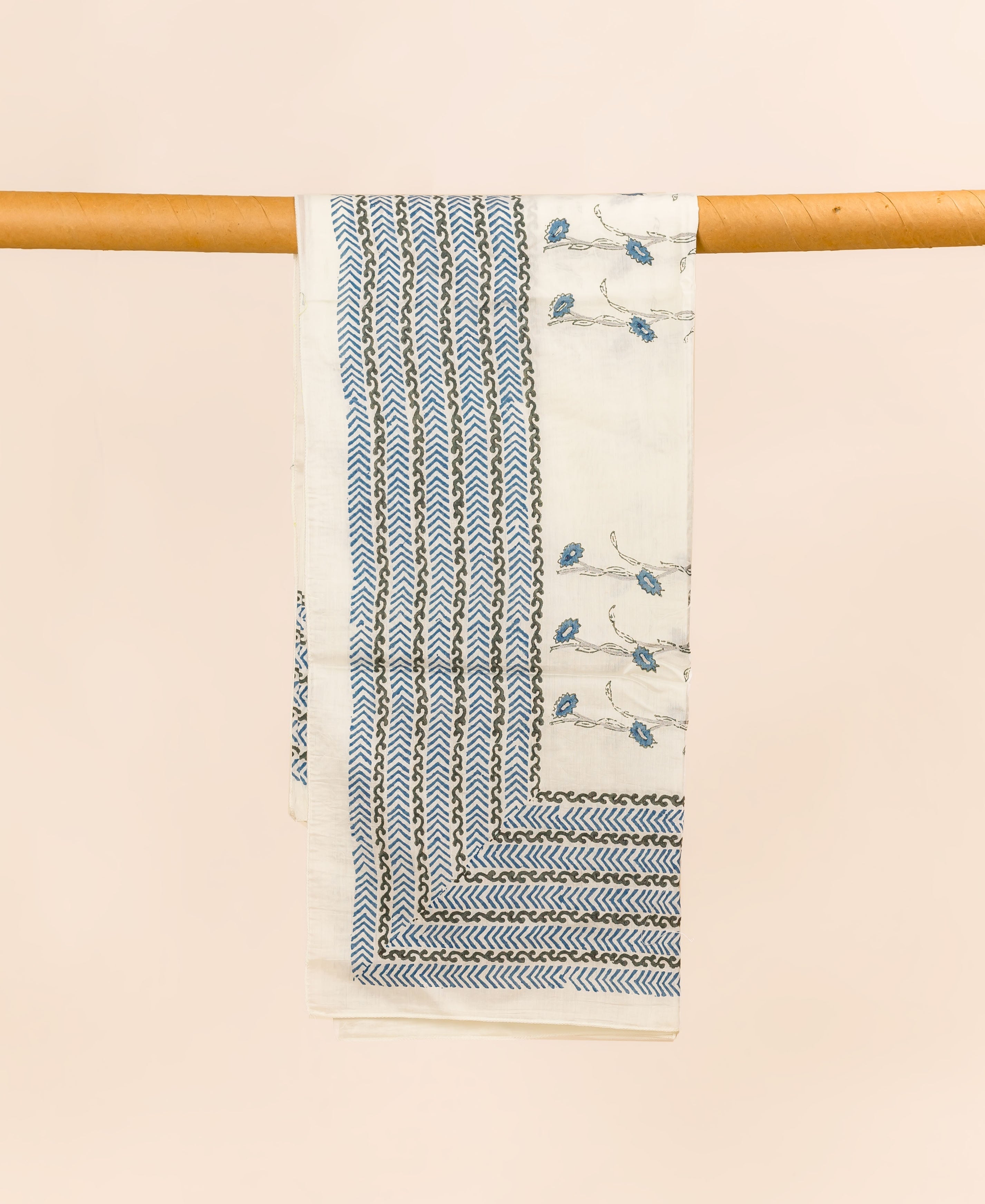 Off-white hand block printed dupatta with blue, dark grey chevron and floral patterns, draped.