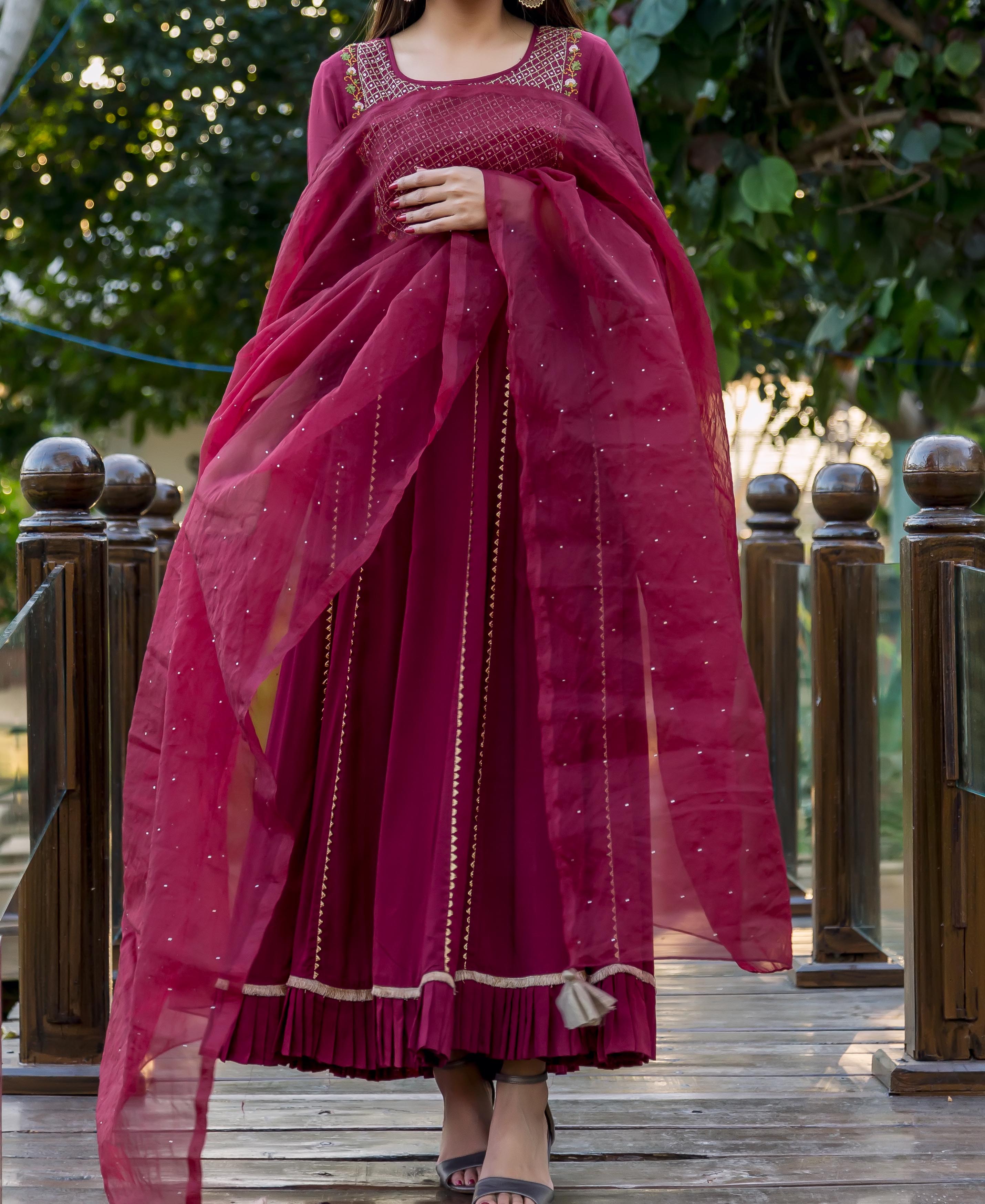 A model wearing a maroon chanderi dupatta with mukaish print, standing on a wooden bridge.