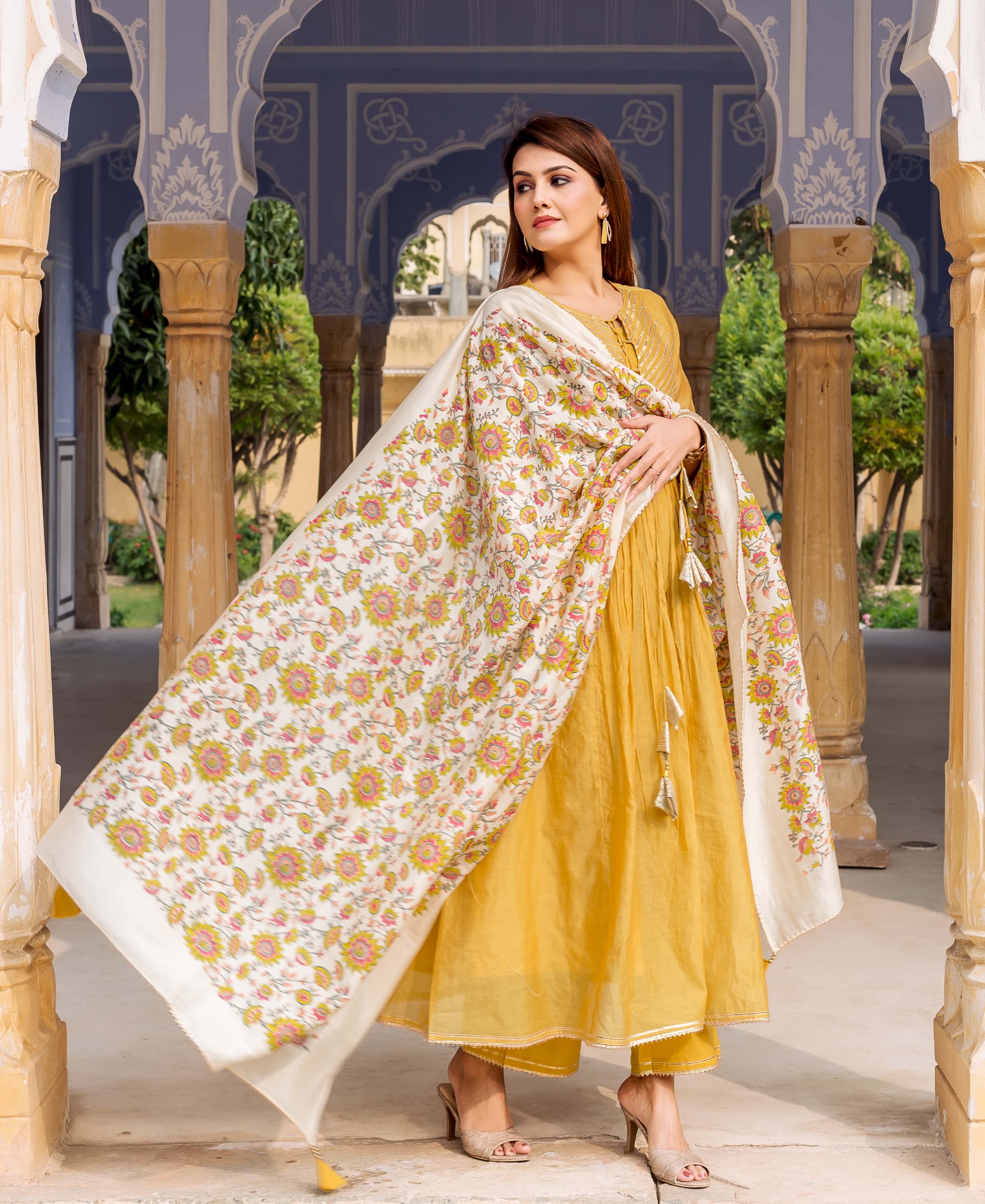 Woman in yellow kurta set, wearing a flowing antique white hand block printed floral dupatta.
