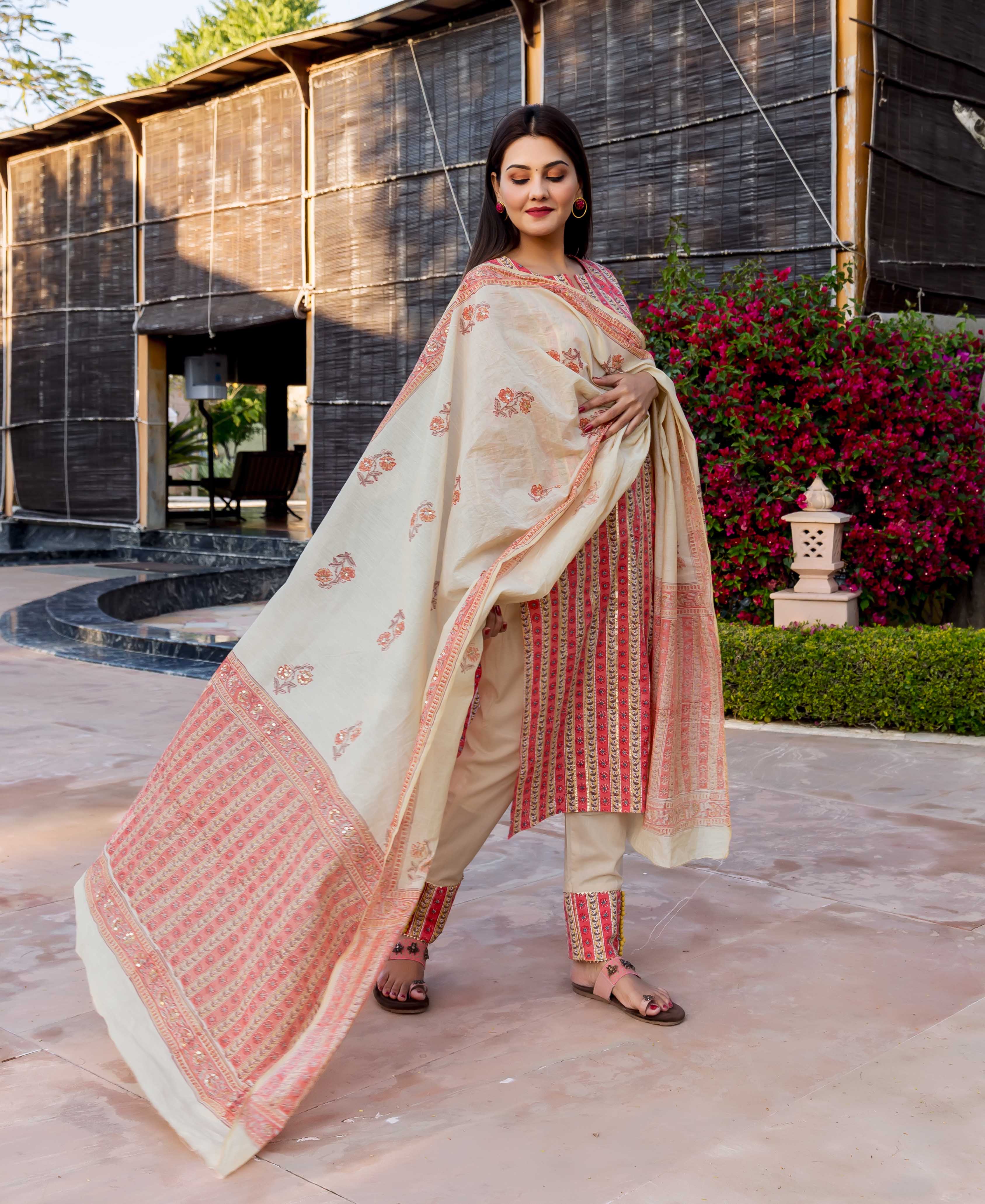 Full-length model in beige and rust hand block printed kurta set with flowing dupatta.