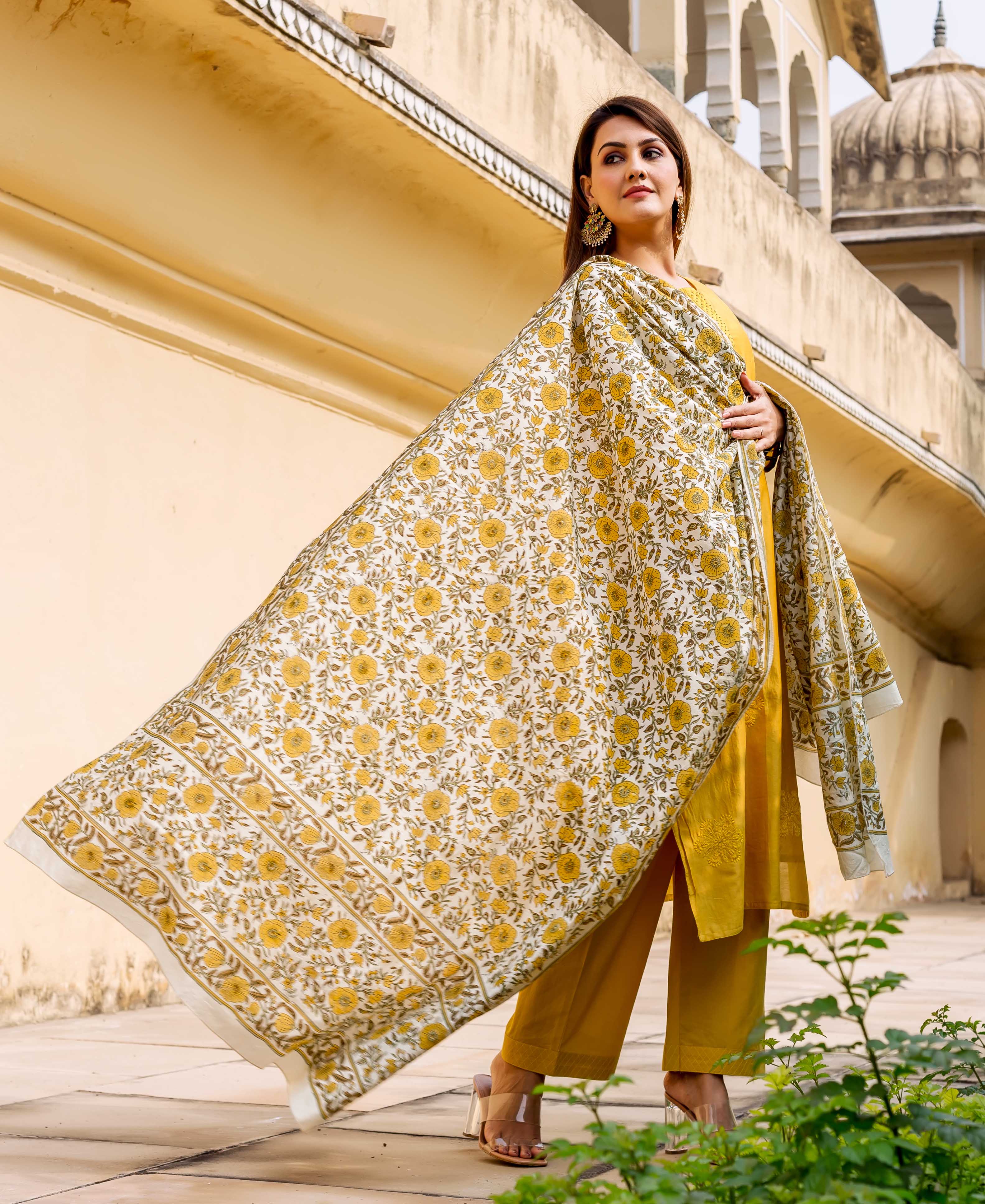 Woman wearing a flowing white and yellow hand block printed floral dupatta with a yellow suit.