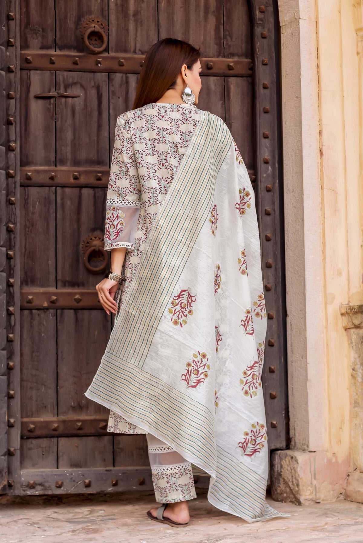 White hand block printed dupatta with red flowers and green stripes on model, back view.