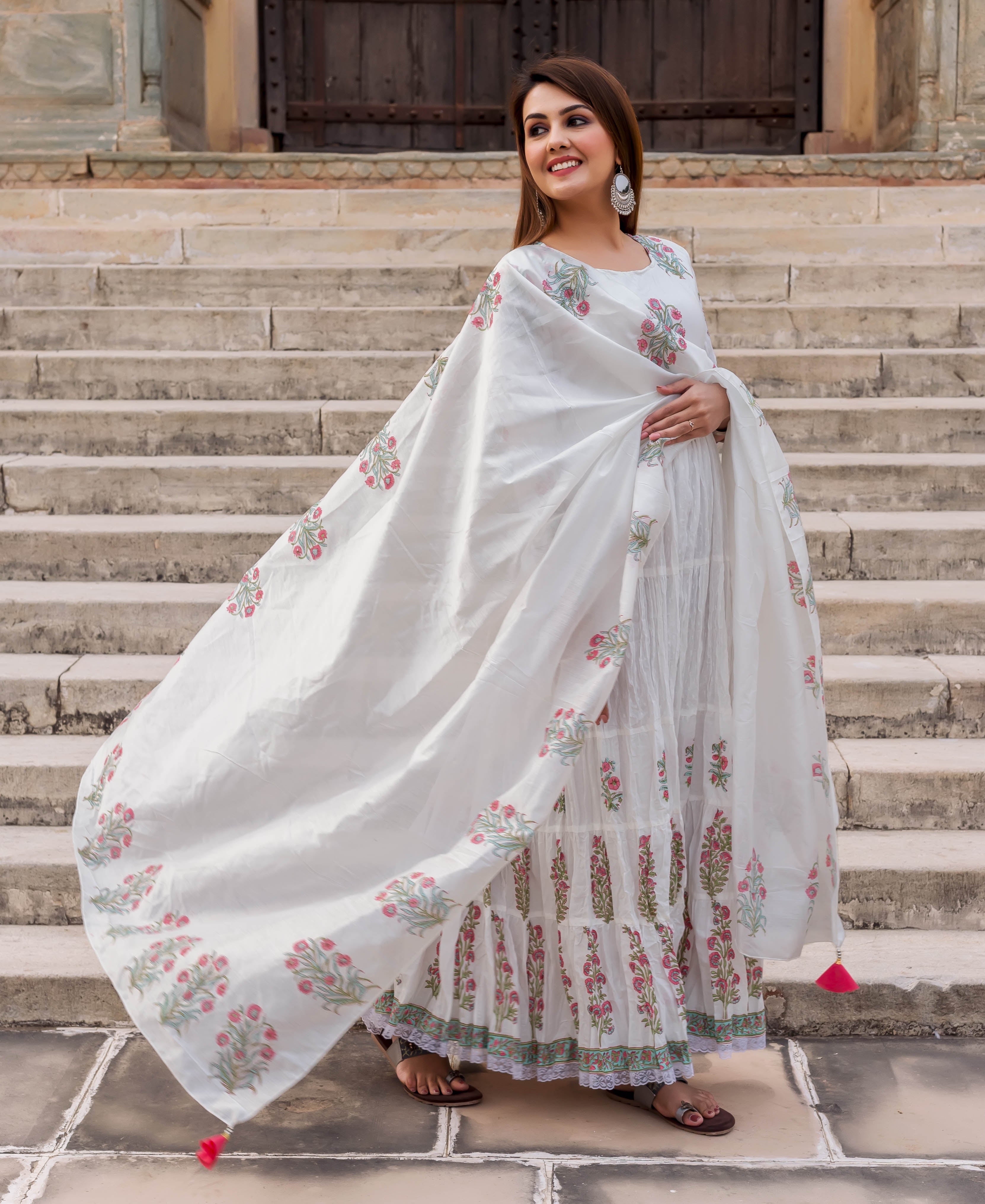 Model wearing a flowing white hand block printed dupatta with vibrant pink and green floral motifs.