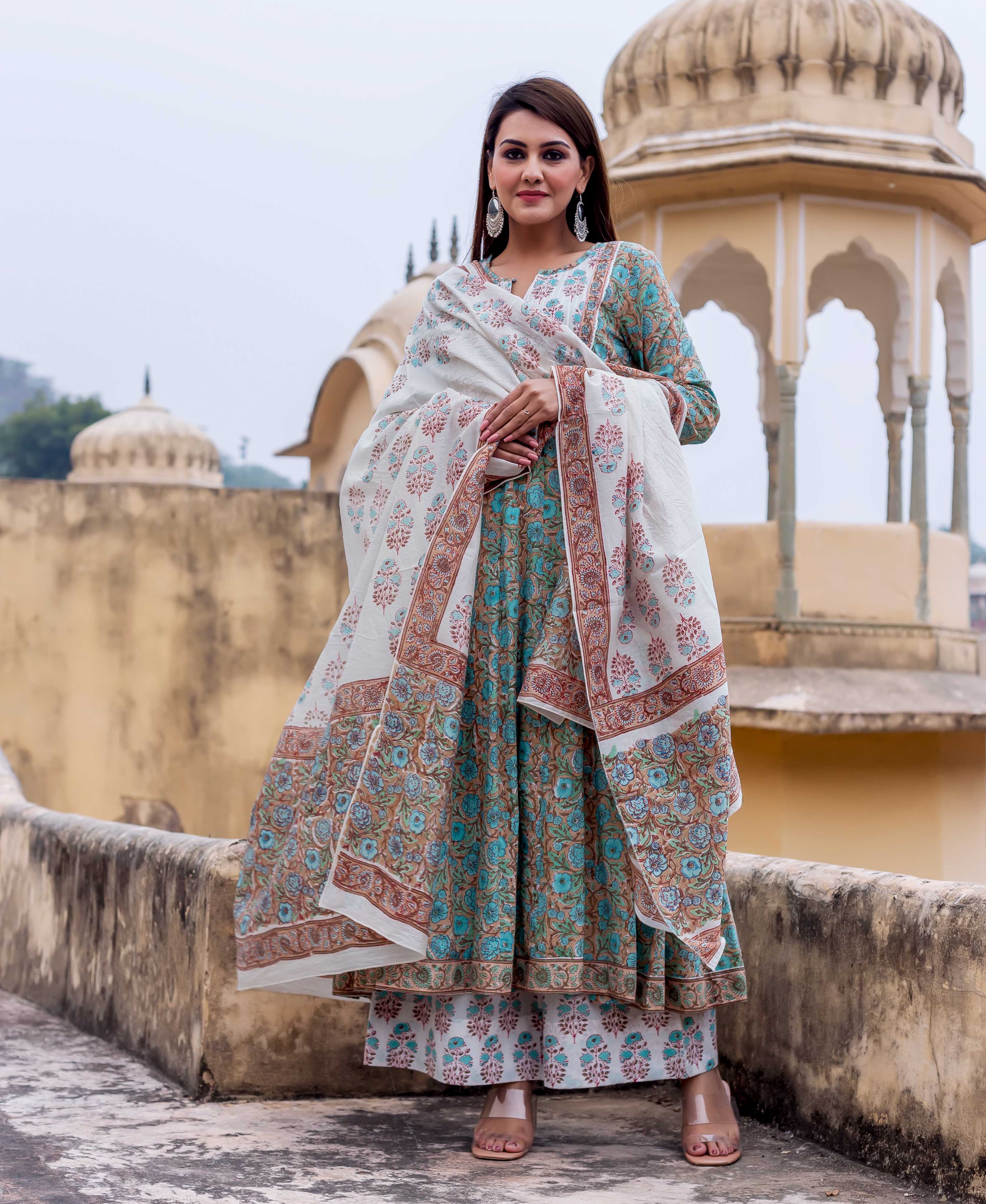 Woman modeling a white and rust hand block printed dupatta over a blue ethnic suit.