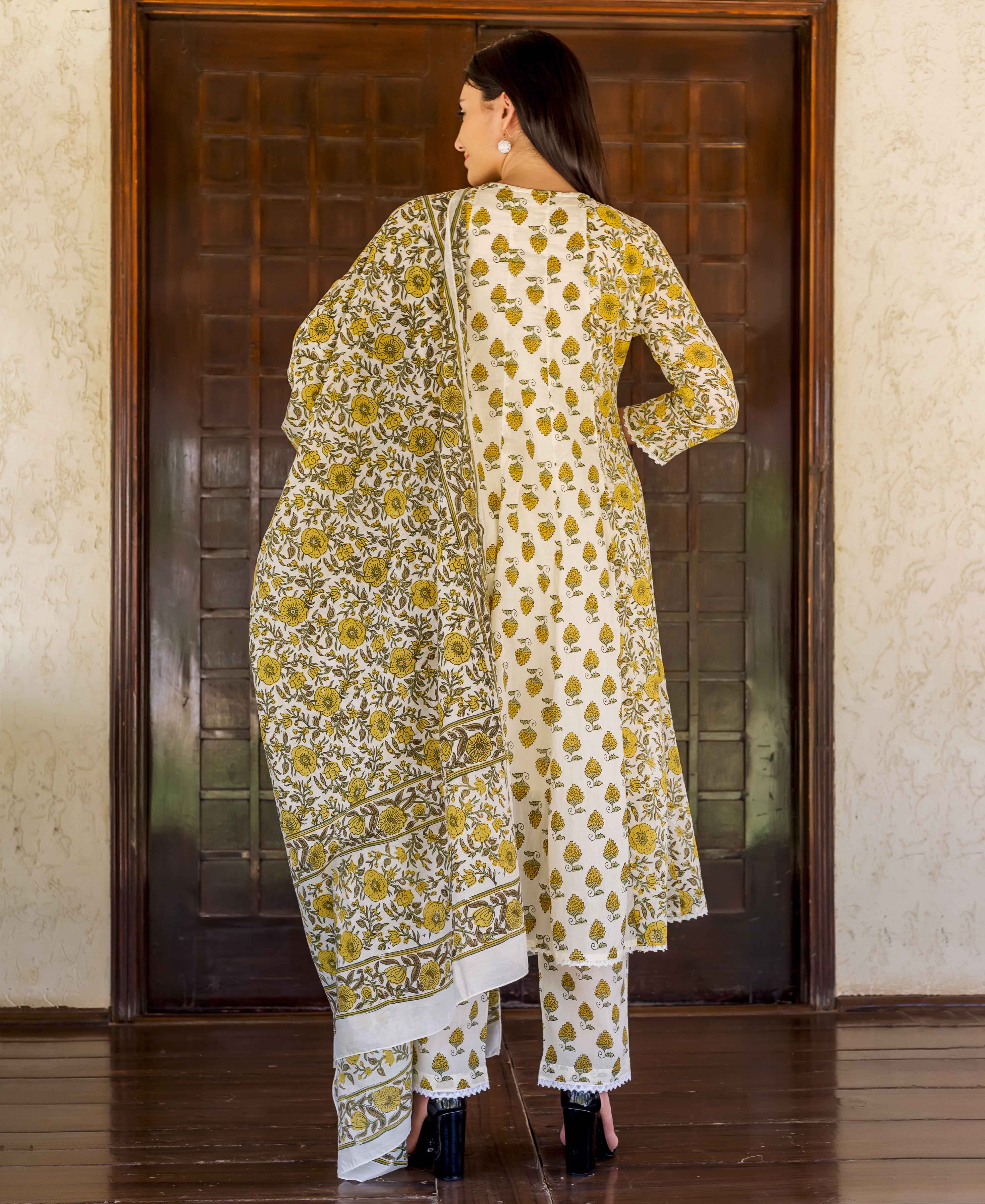 Back view of woman in a white and yellow floral block-printed kurta suit.