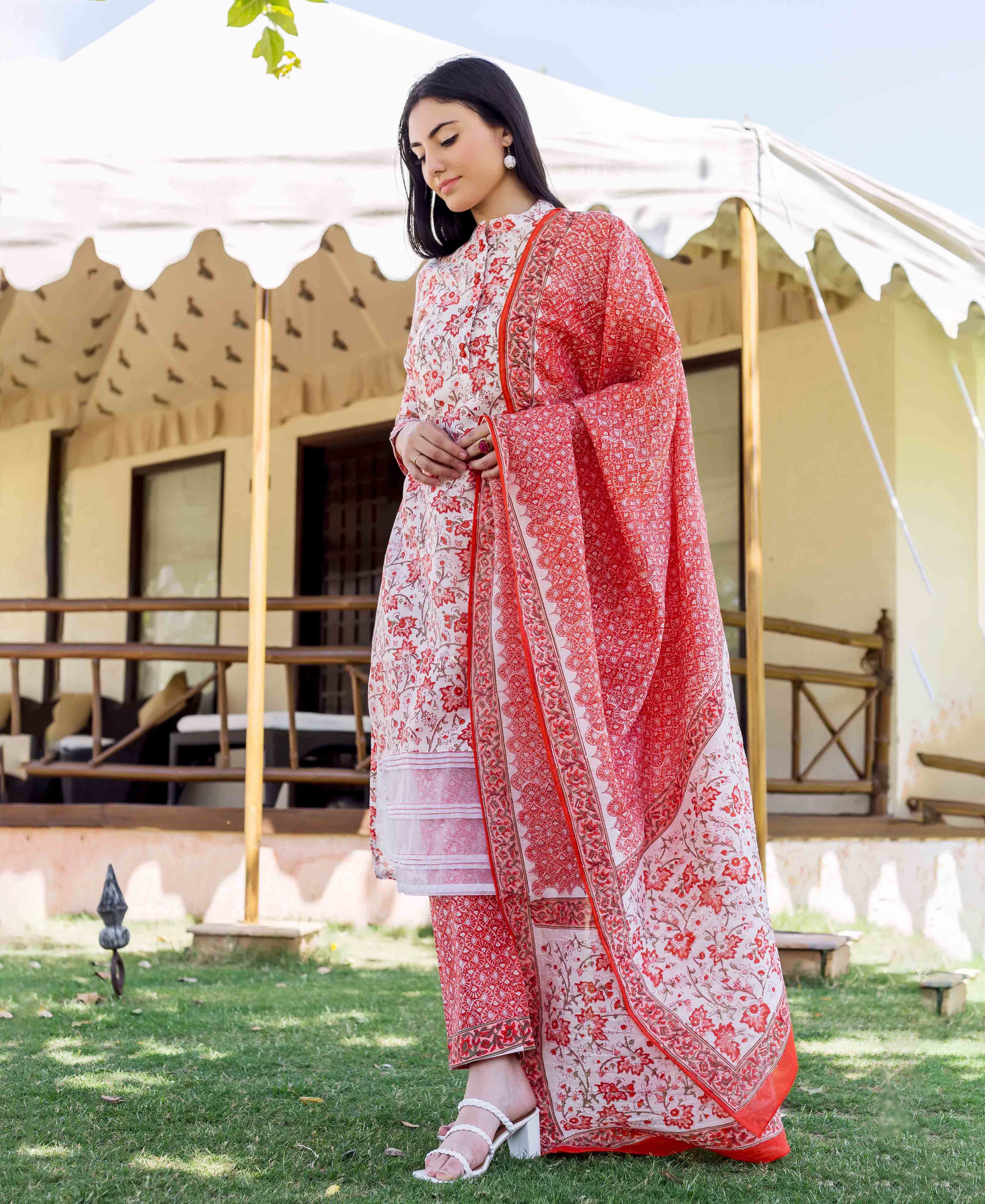 Model wearing a cream and orange floral block printed kurta set with dupatta.
