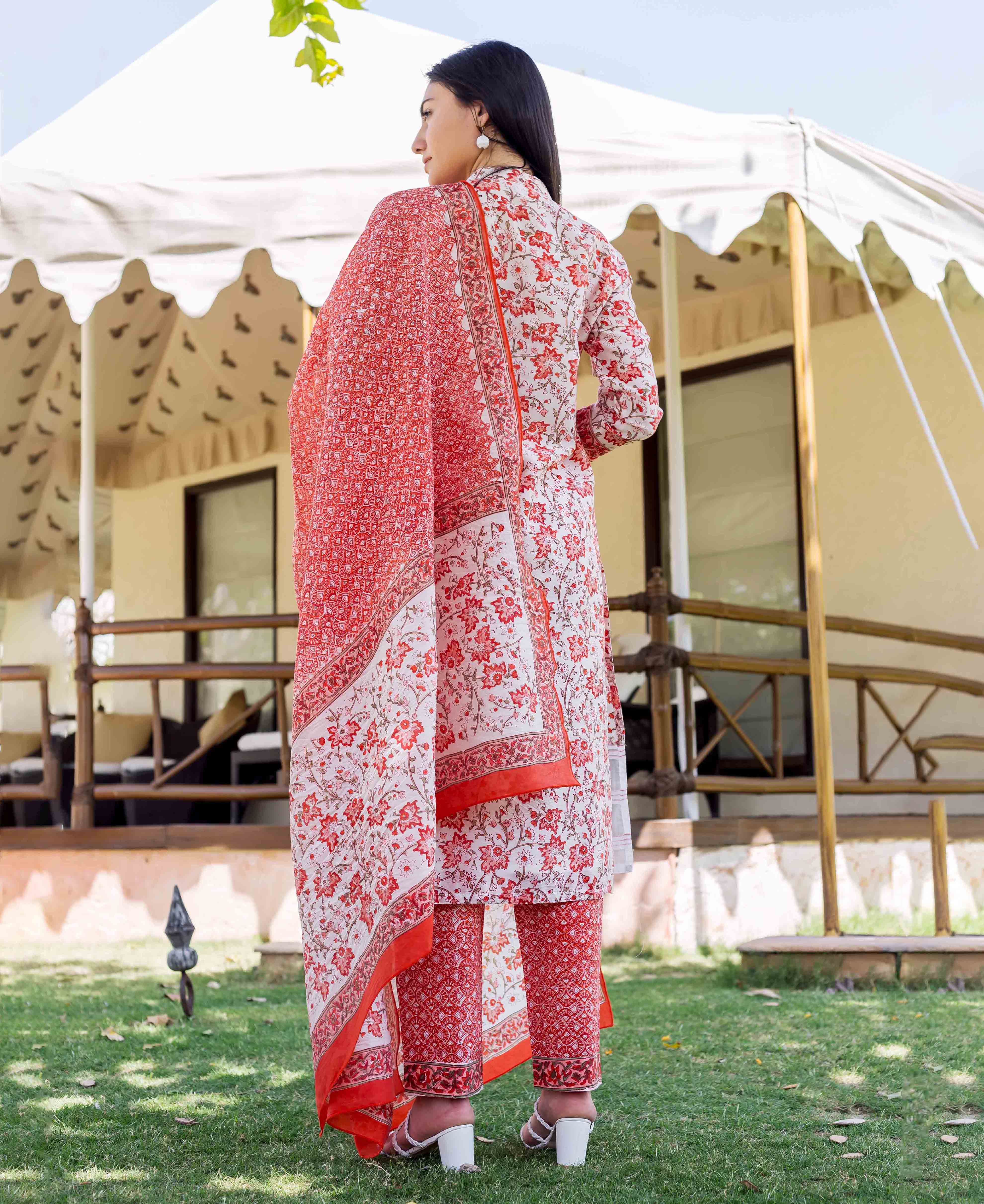 Woman in white and red block-printed kurta set with floral patterns, seen from back.