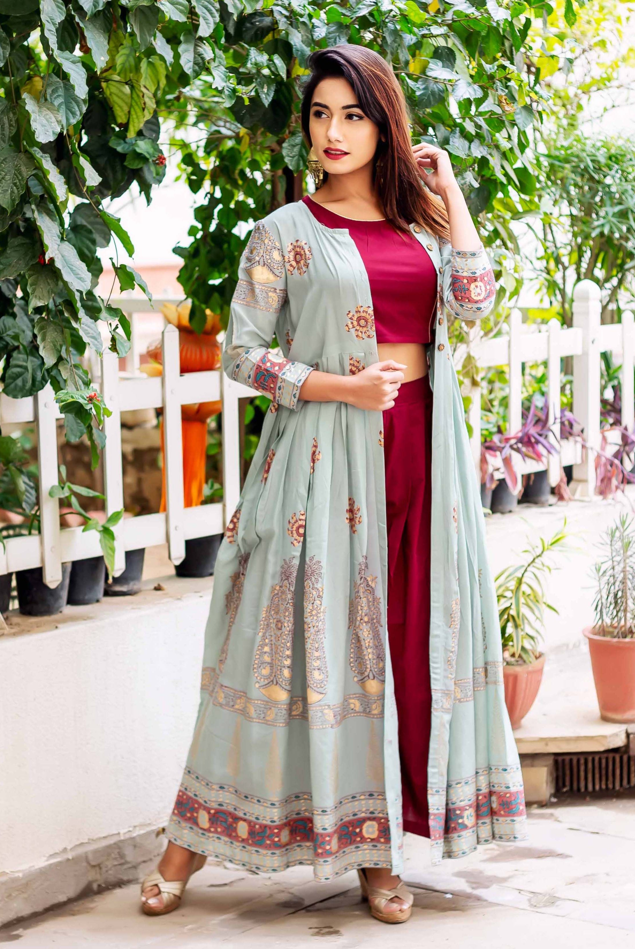 Model wearing sage blue ethnic hand-block-printed floor-length jacket, maroon crop top, and pants.
