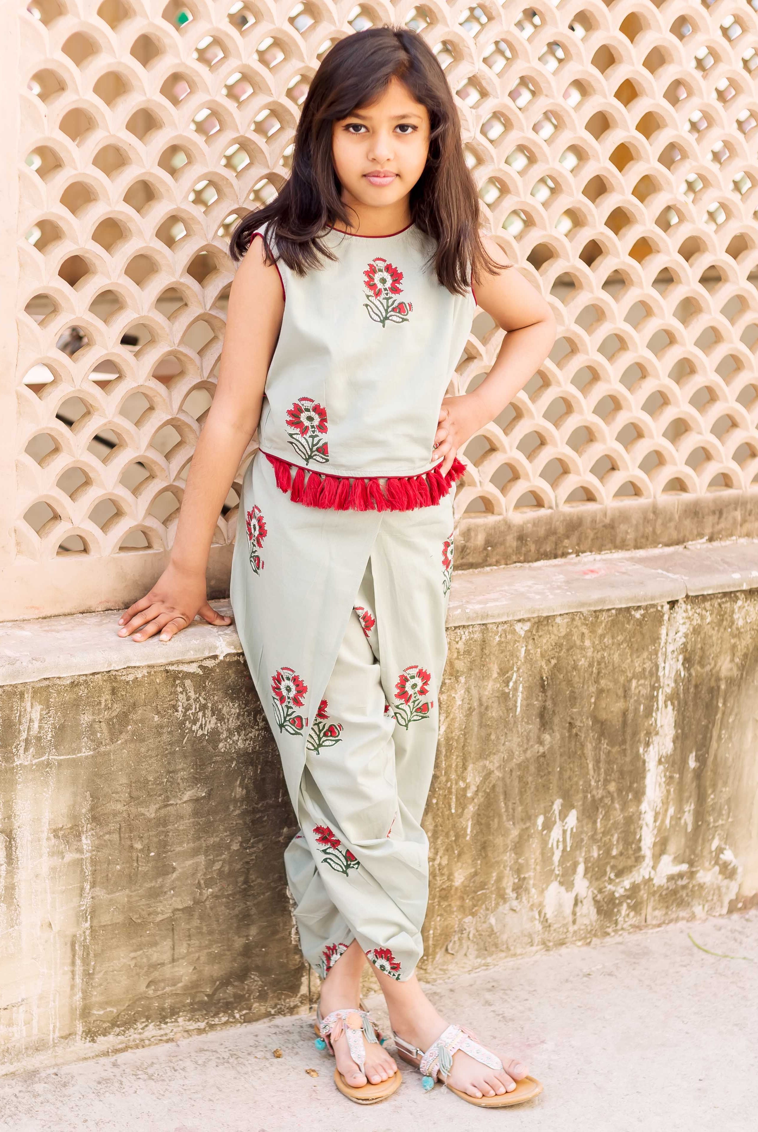 Young girl in frosty mint crop top and dhoti with red floral block print.