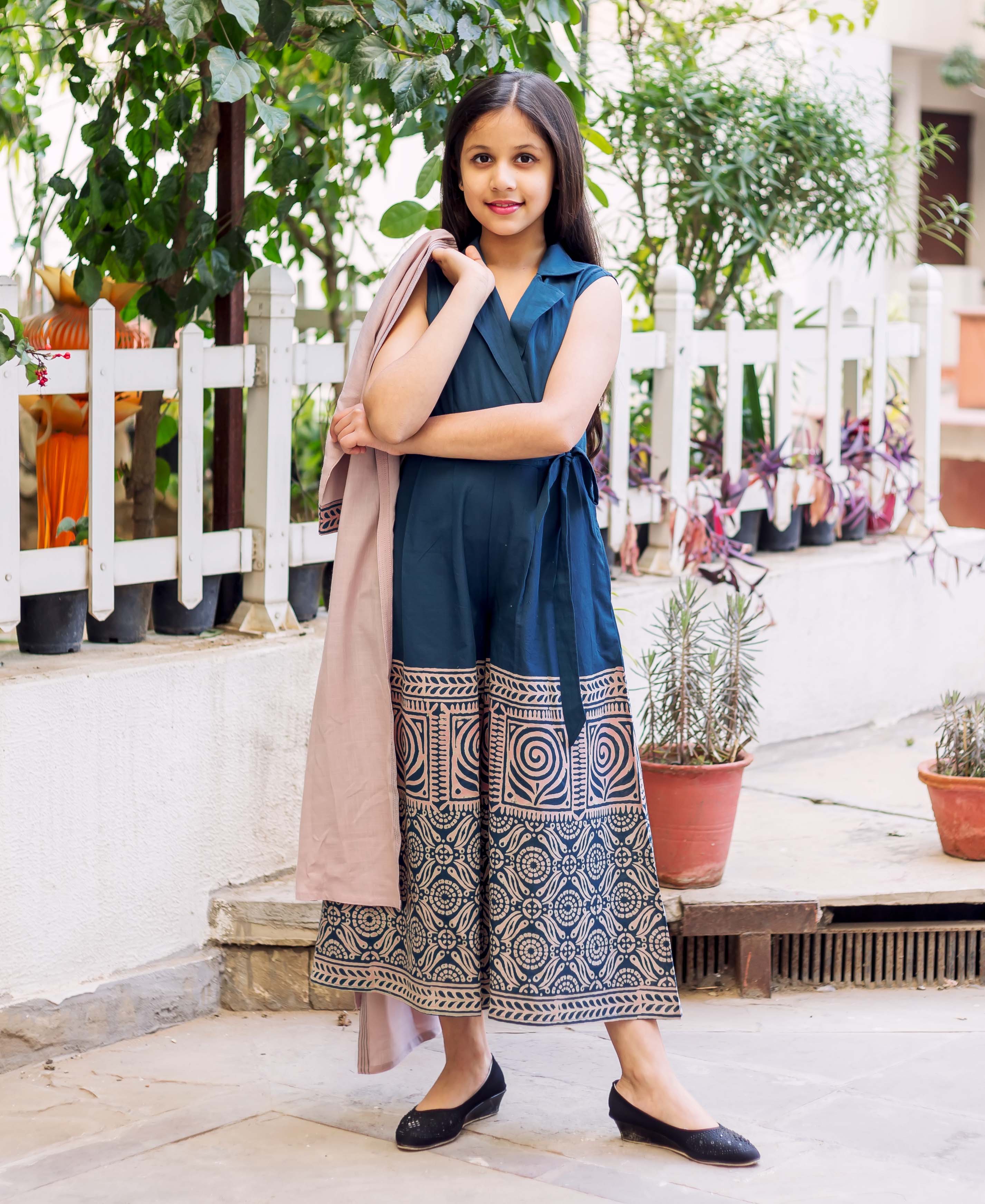 Young girl in indigo blue hand-block printed cotton jumpsuit with light pink detachable jacket.