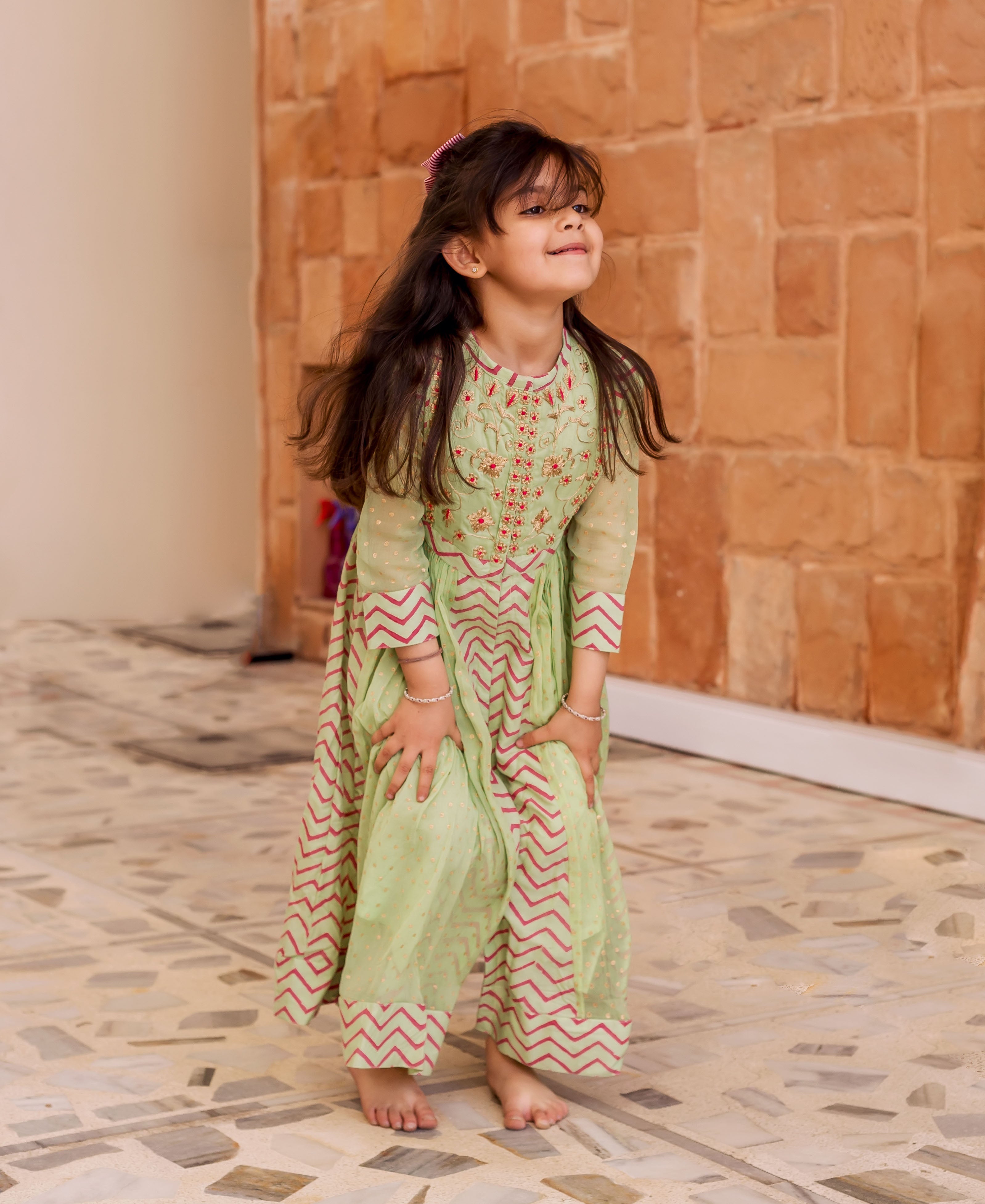 Mint green chiffon Anarkali dress for baby girl, with red zigzag print and embroidered bodice.