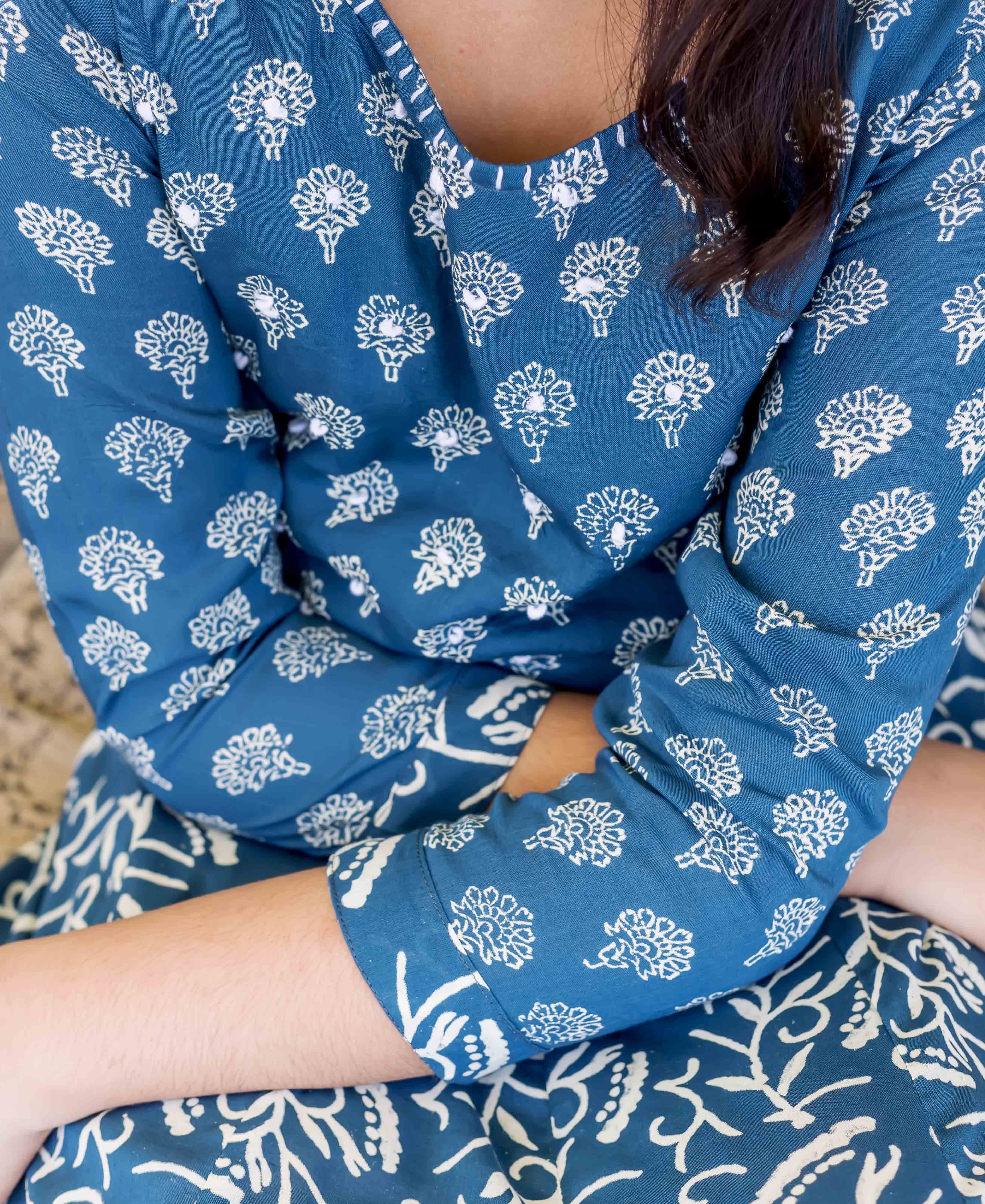 Front close-up of a person wearing an indigo blue ethnic outfit with white hand-block printed floral patterns.