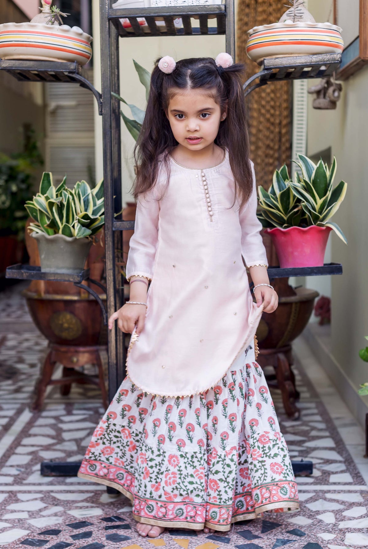Pink embroidered straight short kurta with white printed sharara featuring pink floral designs.