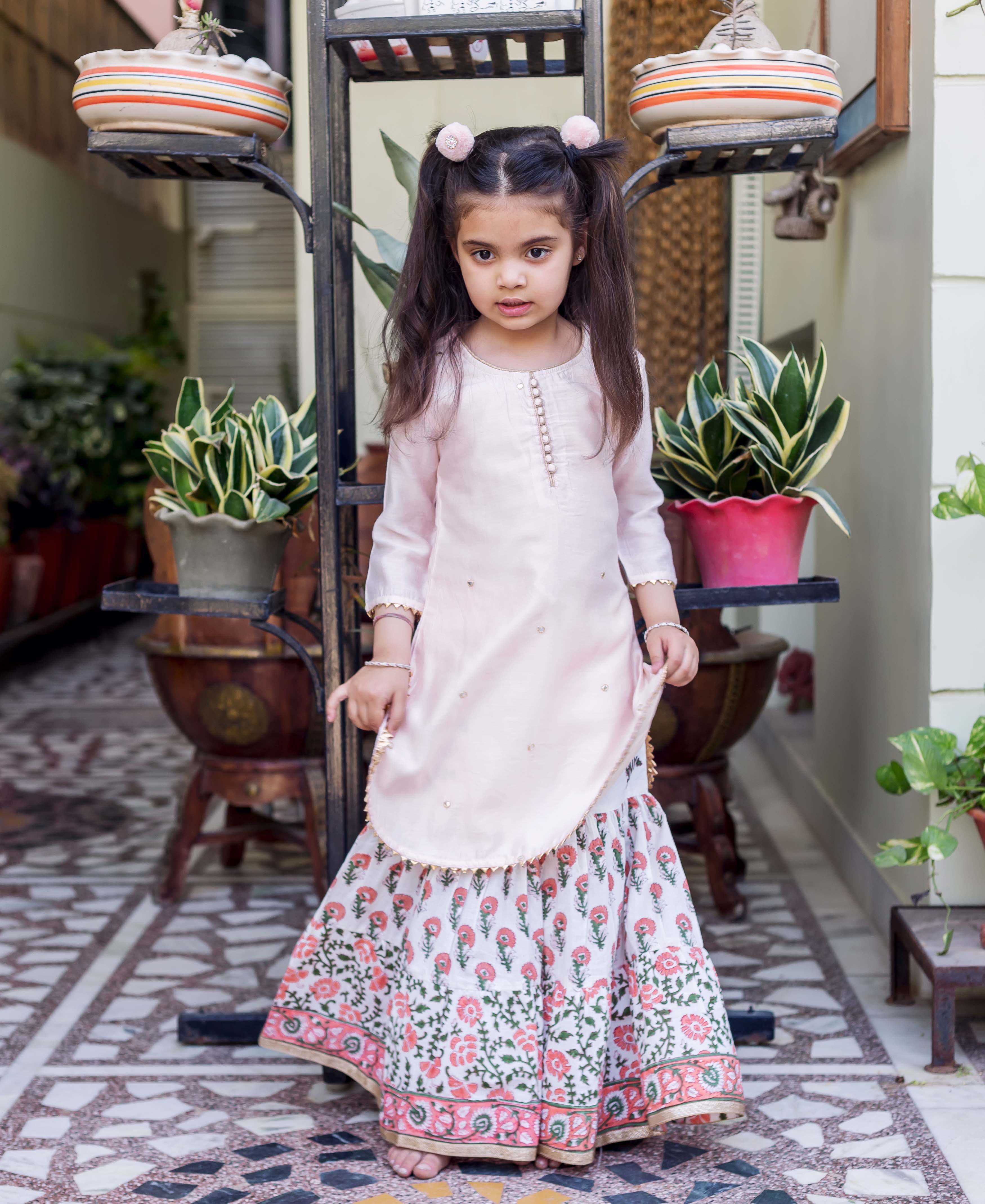 Pink embroidered straight short kurta with white printed sharara featuring pink floral designs.