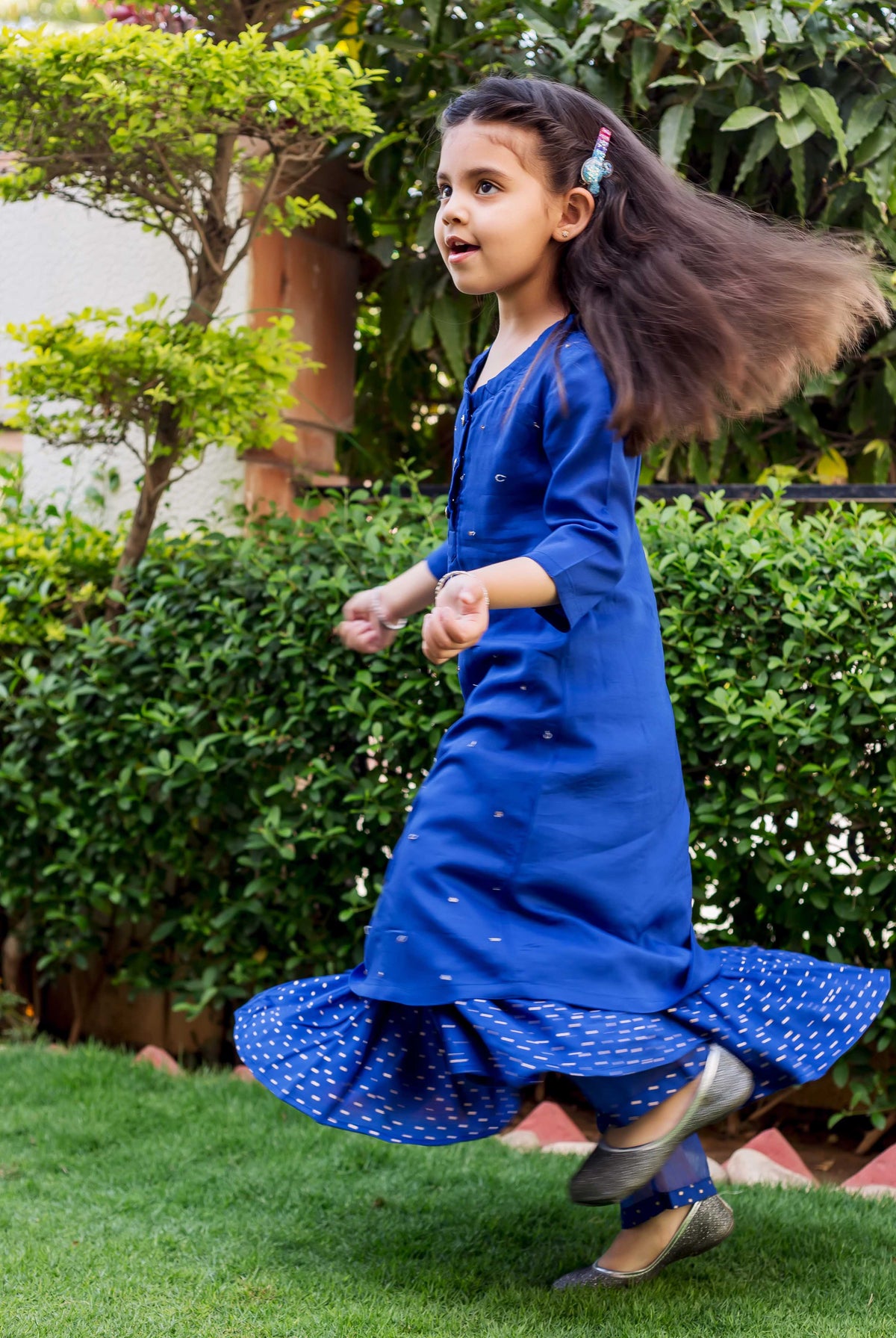 Azure blue embroidered suit set on girl, side view, layered polka dot bottoms.