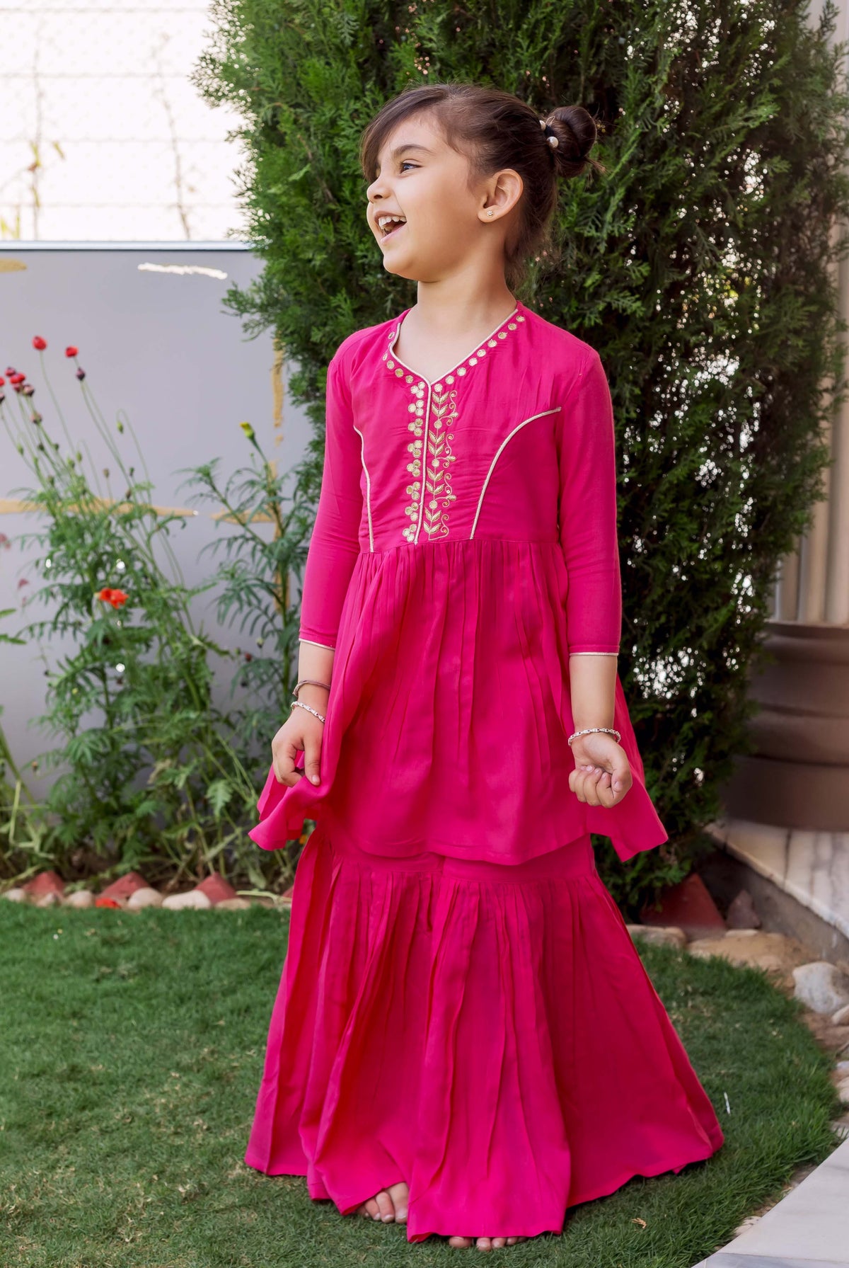 Vibrant French Rose sharara set on young girl, hand embroidery on yoke, front view.