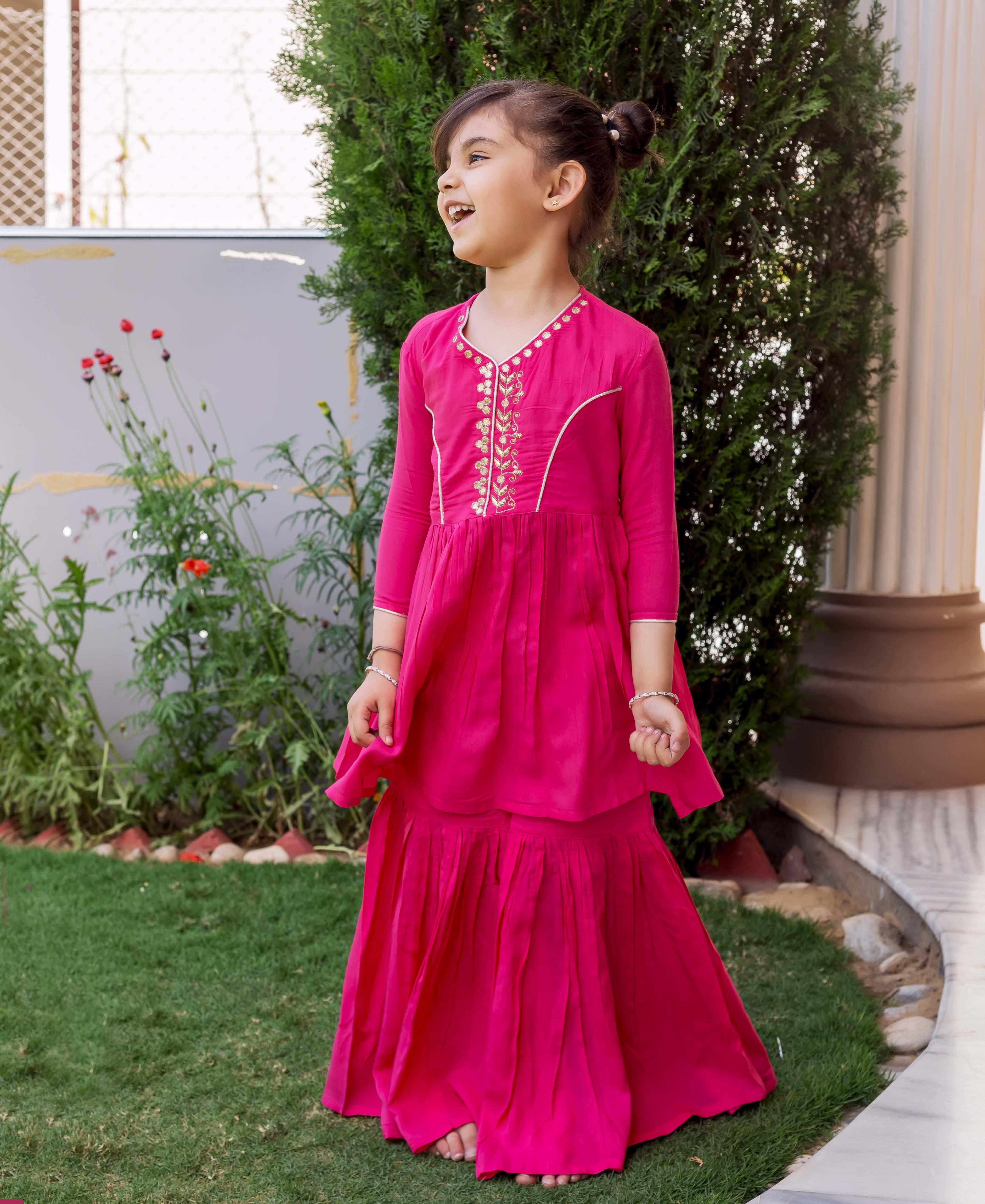 Vibrant French Rose sharara set on young girl, hand embroidery on yoke, front view.