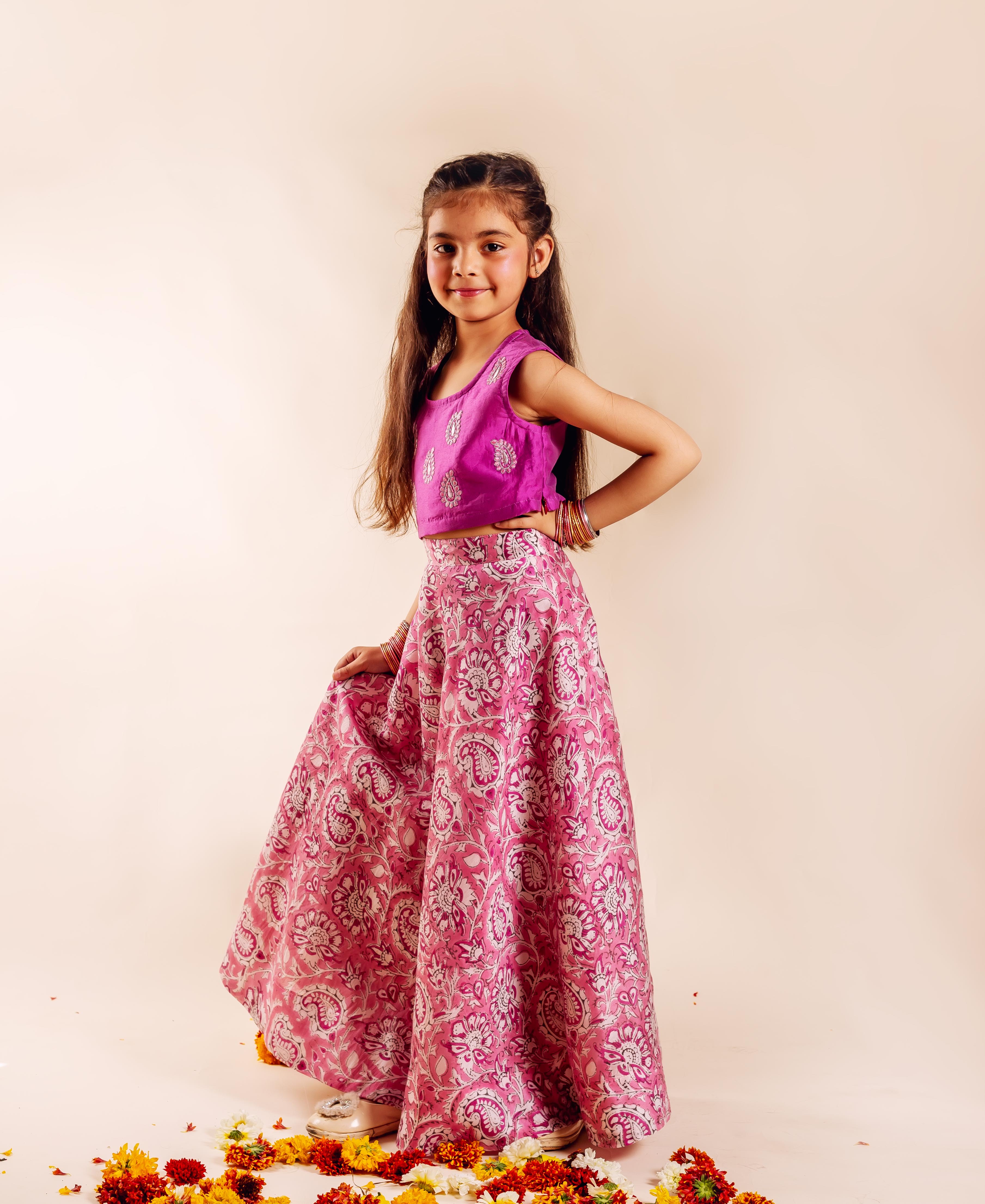 Front full-length of young girl in a magenta pink hand-block-printed lehenga set.