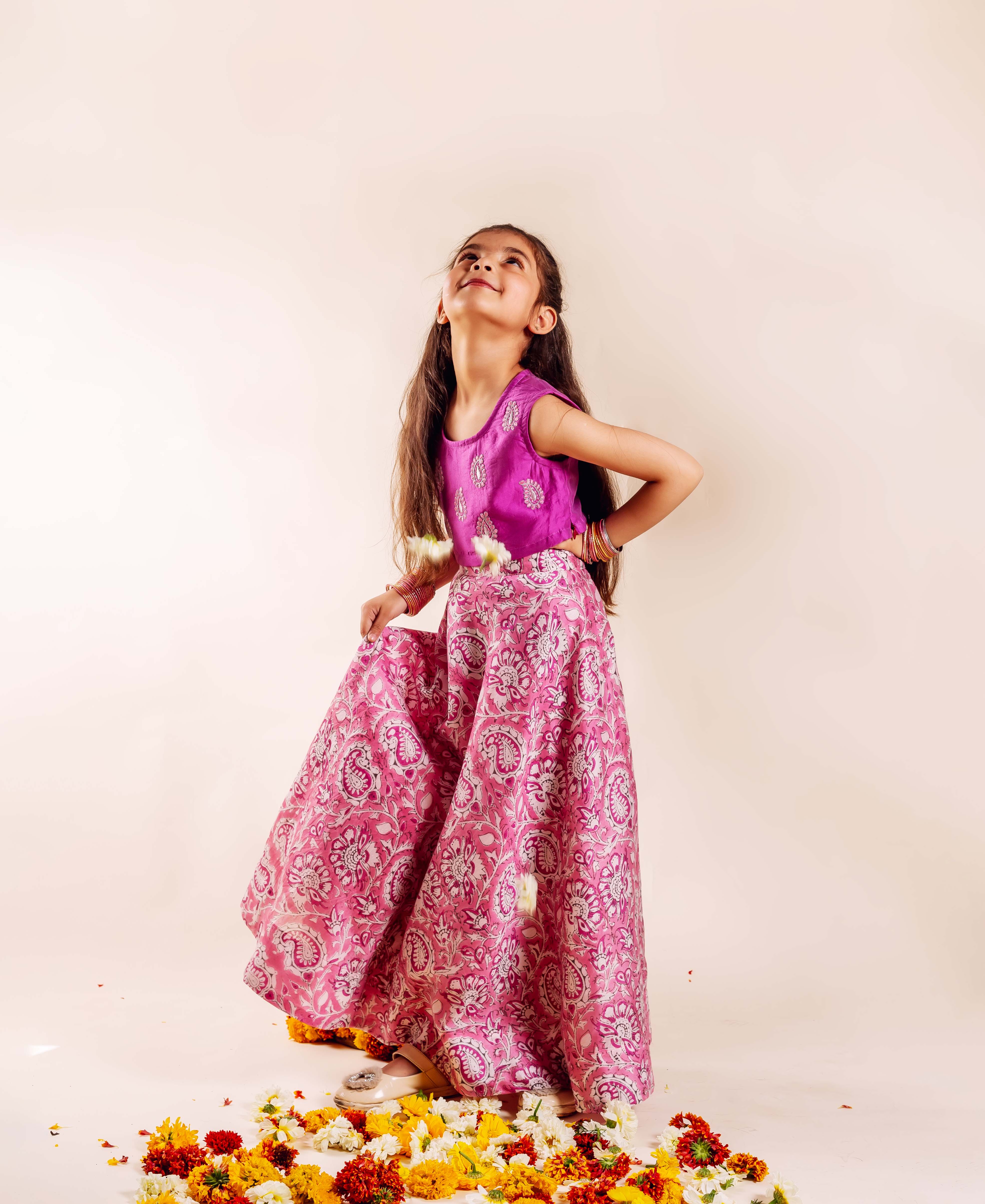 Young girl wearing a full magenta and pink floral hand-block-printed lehenga set.