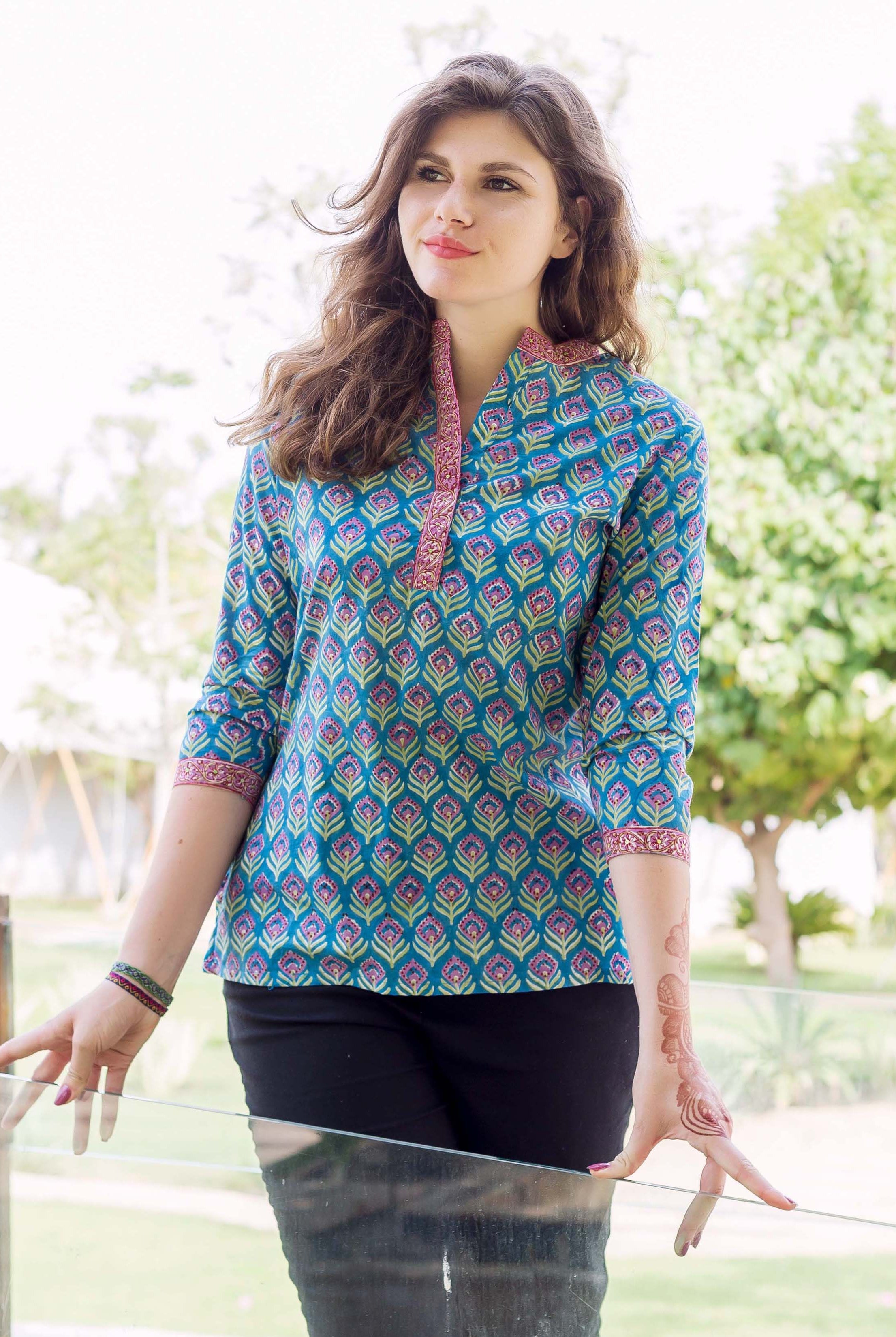 Model wearing a blue hand block printed ethnic top with pink and green print.