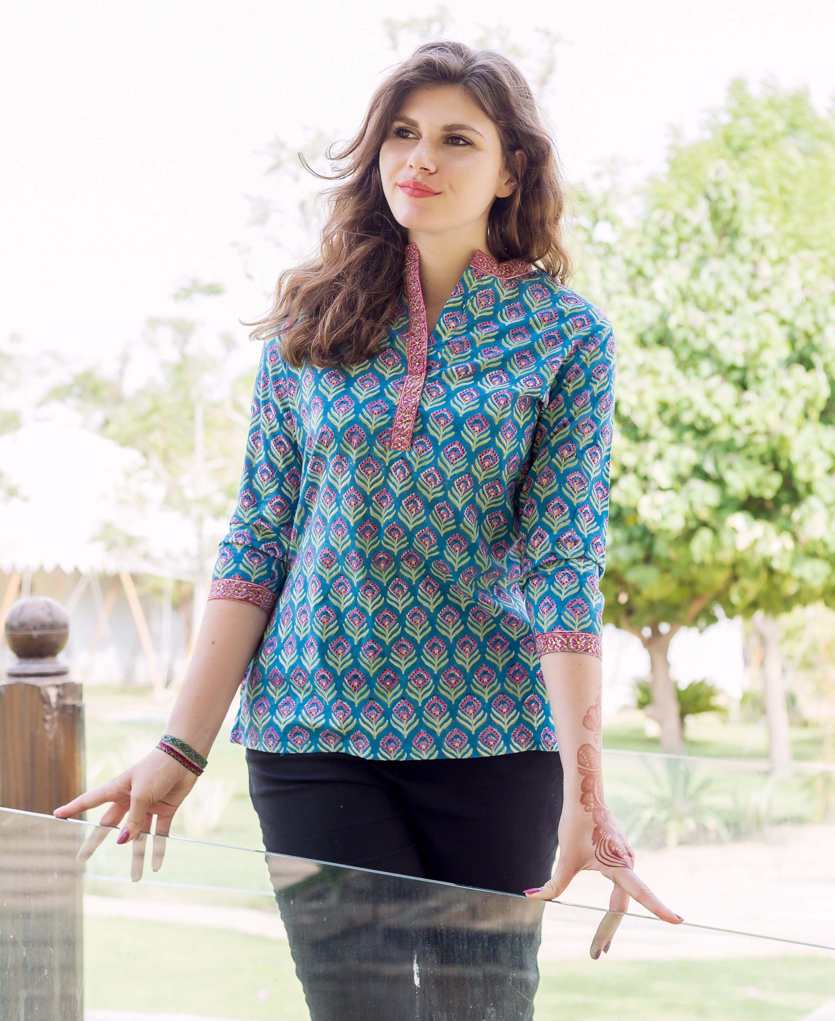 Model wearing a blue hand block printed ethnic top with pink and green print.