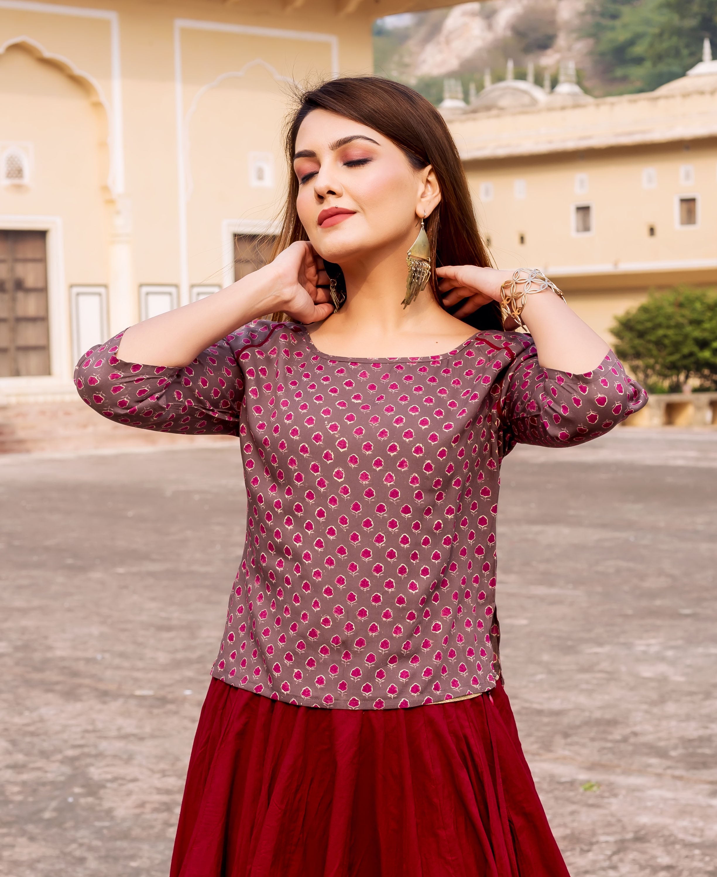 Model in maroon and brown hand-block printed ethnic short top, paired with a maroon skirt.