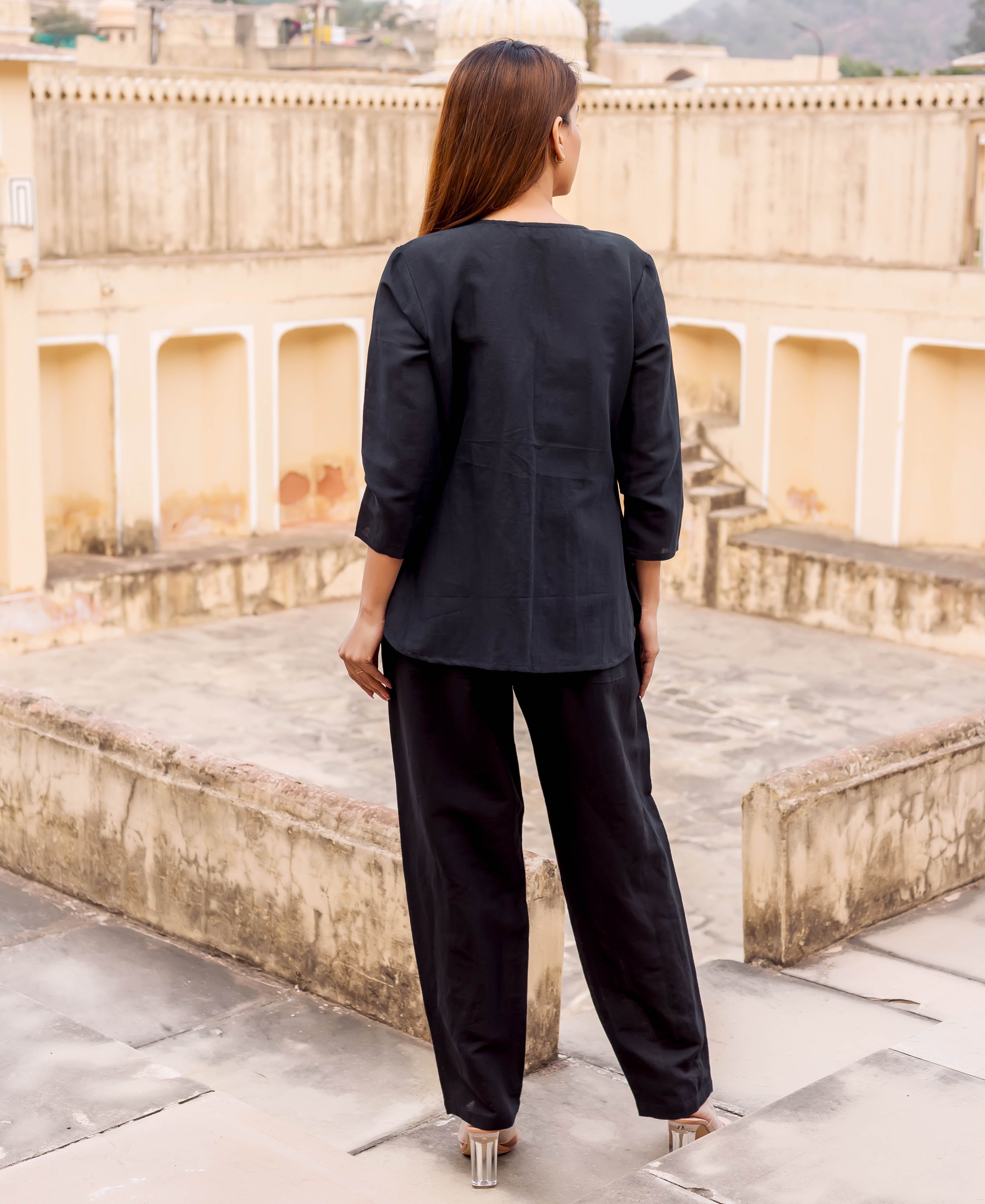 A woman wearing a black linen power suit with a hand-block-printed ethnic design.