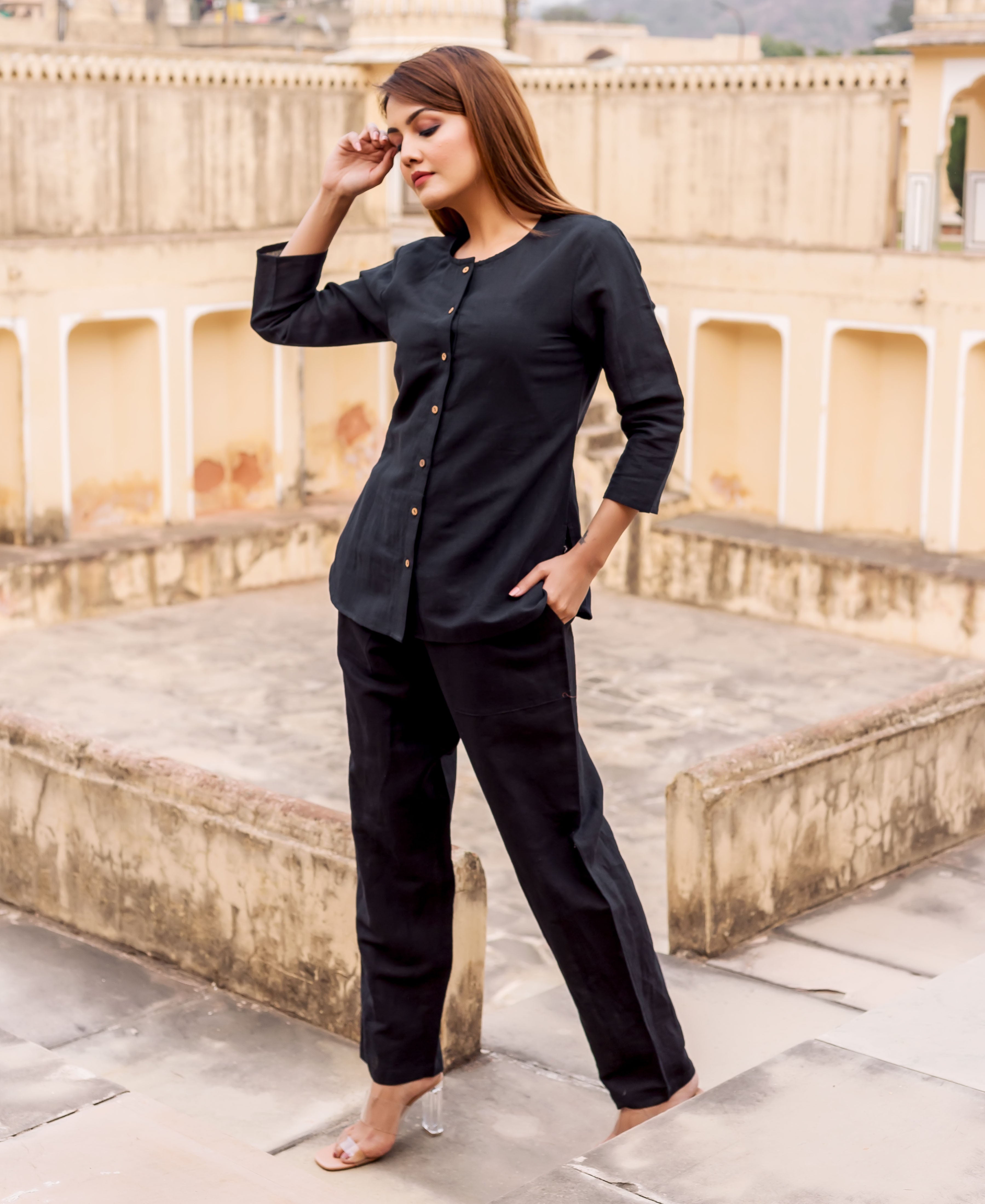 Full-length view of model wearing a black linen button-up top and matching trousers.