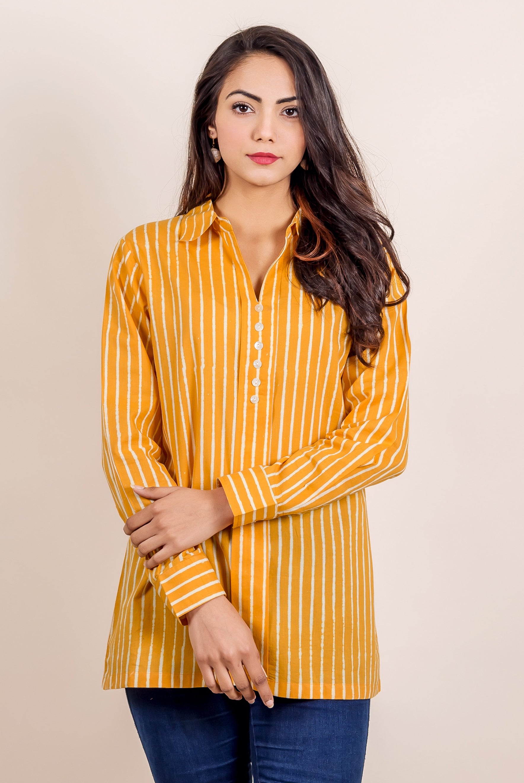 Model wears a yellow hand-block printed shirt top with white stripes, paired with blue jeans.