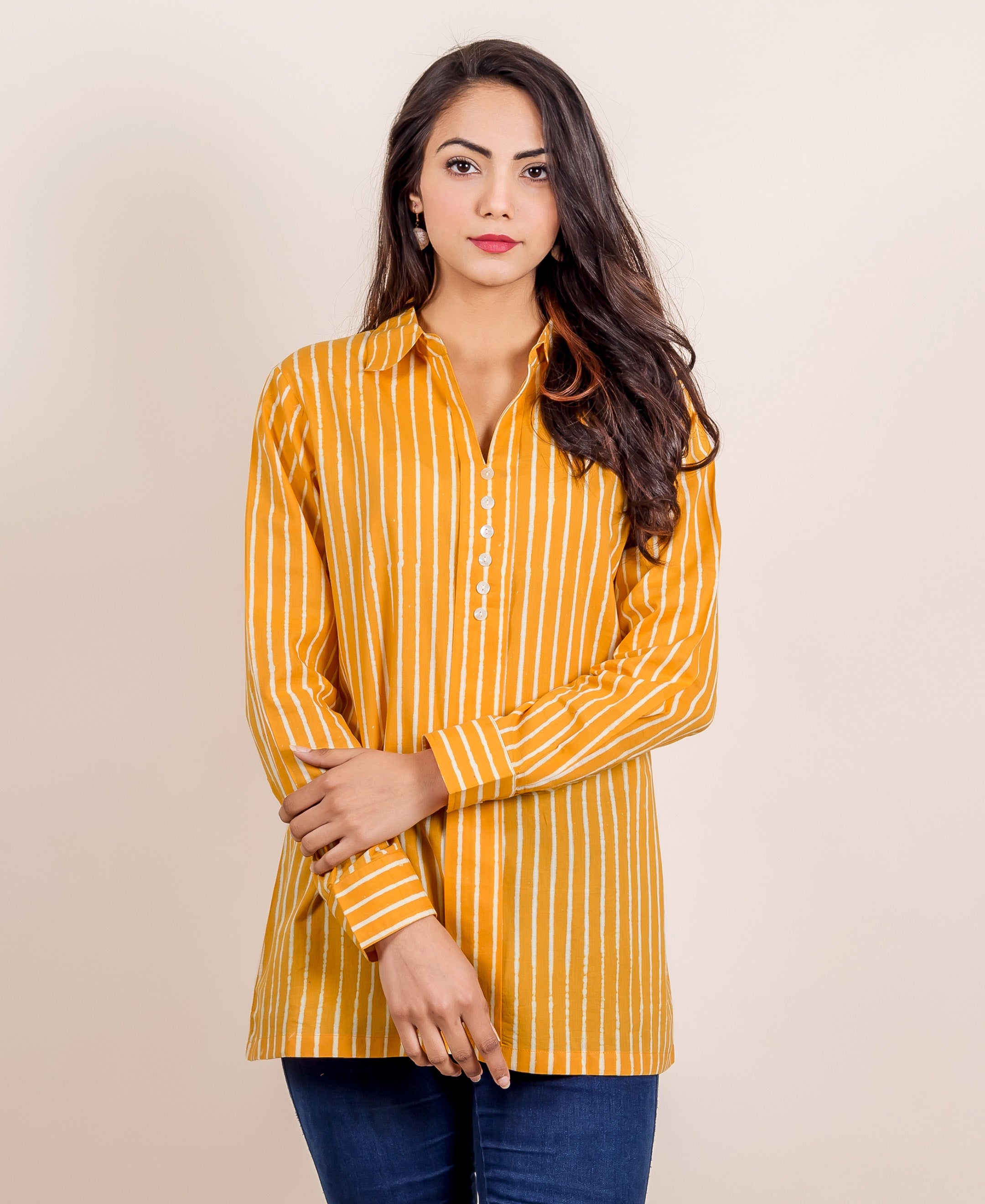 Model wears a yellow hand-block printed shirt top with white stripes, paired with blue jeans.