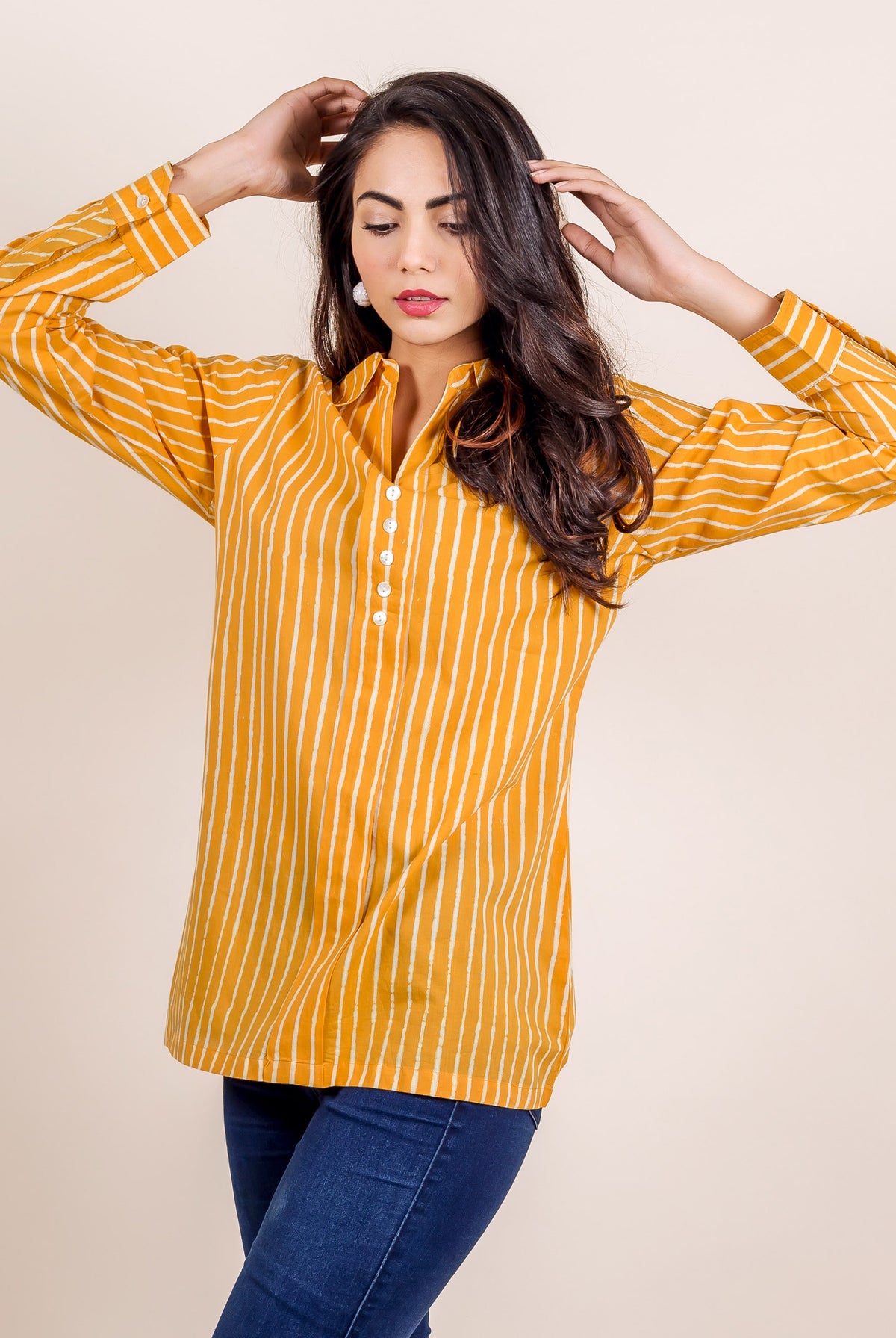Woman wearing a yellow striped hand block printed shirt top.